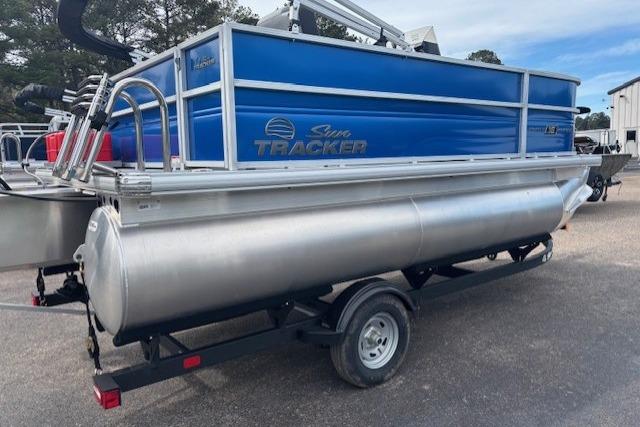 2026 Sun Tracker Party Barge 16 DLX pontoon boat on trailer, blue and silver design.