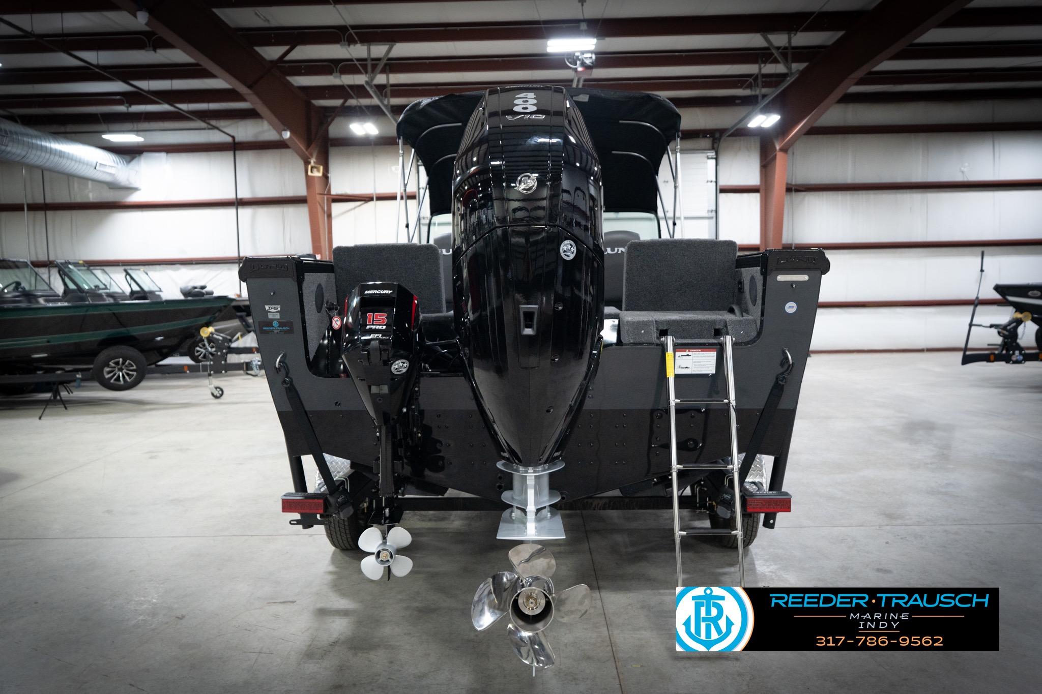 2026 Lund 2275 Baron boat in showroom, rear view with outboard motor.