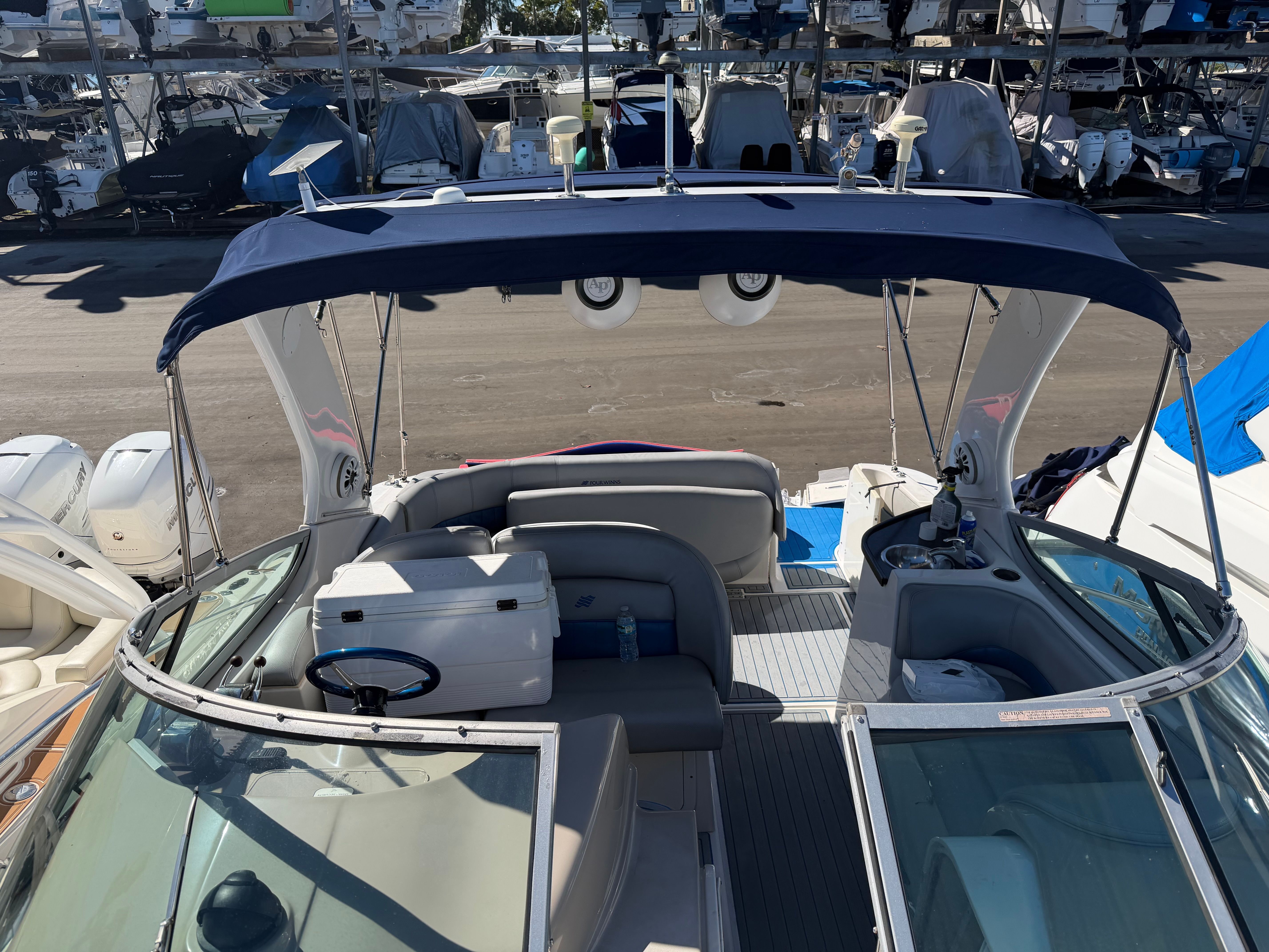 2006 Four Winns 328 Vista boat with canopy in marina.