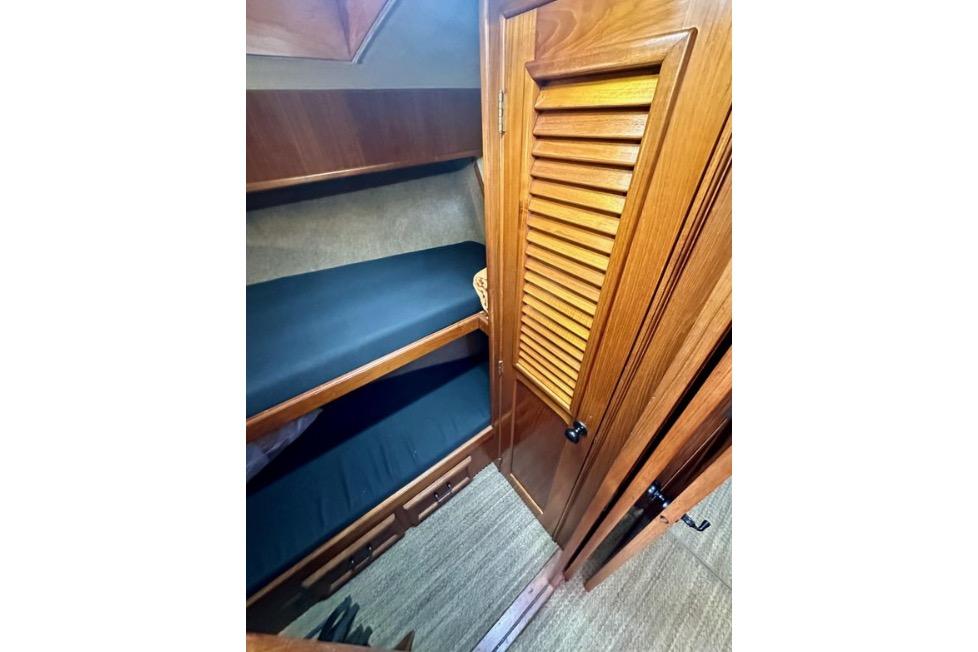 Interior of 1985 Egg Harbor 33 Sedan with wooden bunk beds and closet.