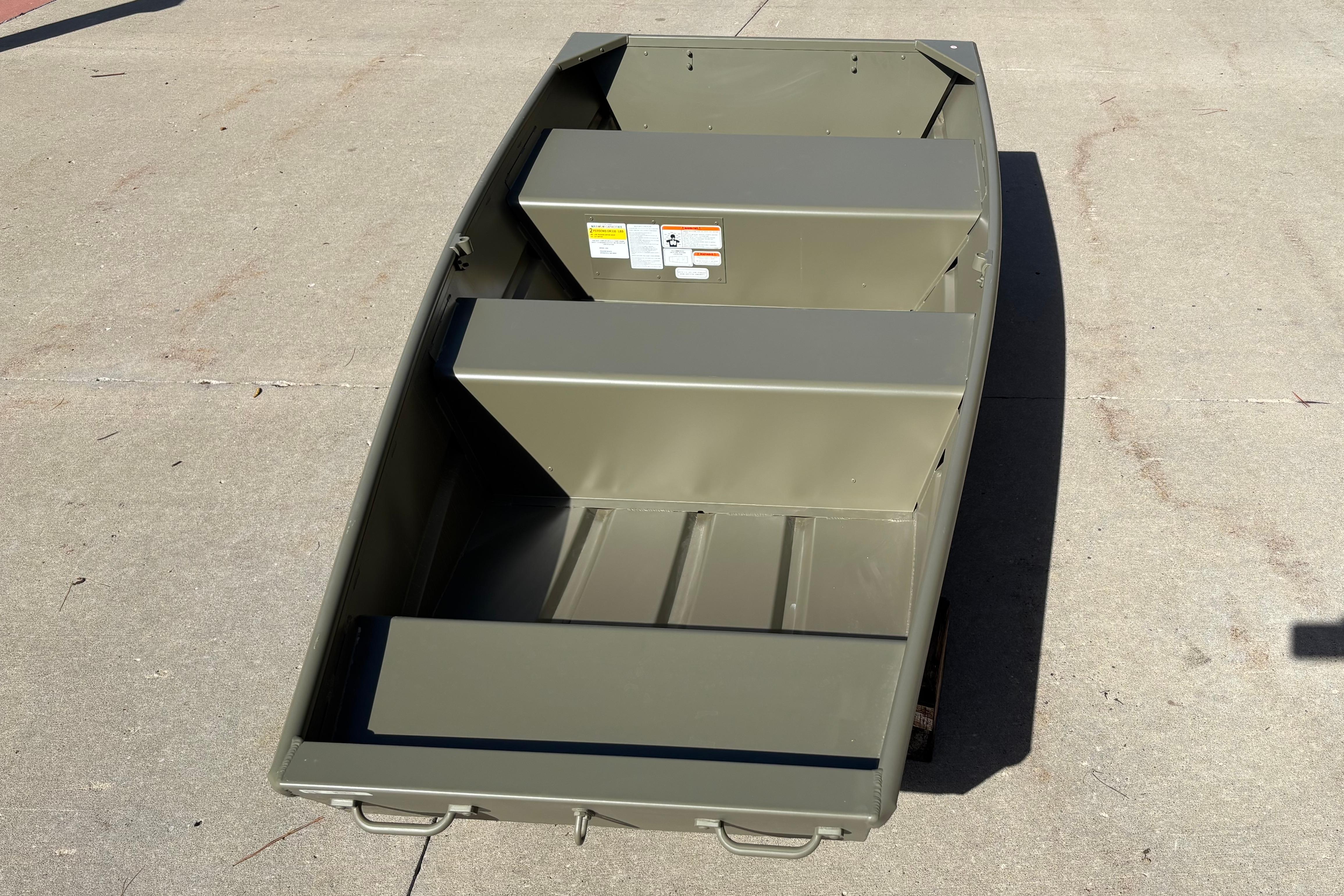 2026 Tracker Grizzly 10 Jon boat on concrete surface, showcasing interior seating and storage.