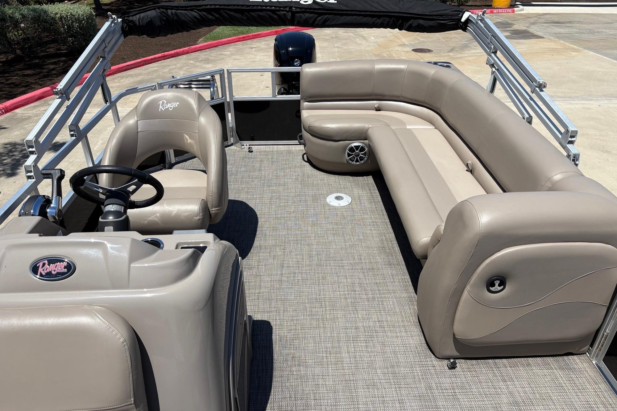 2024 Ranger Reata 200C pontoon boat interior with beige seating and steering console.