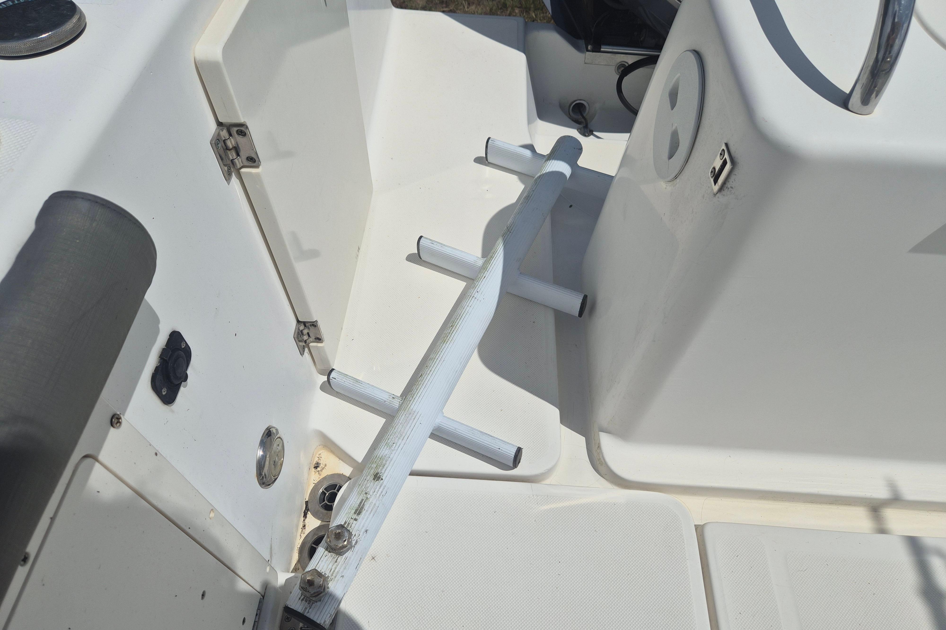 2006 Century 2900 Center Console boat interior with rod holders and storage compartment.