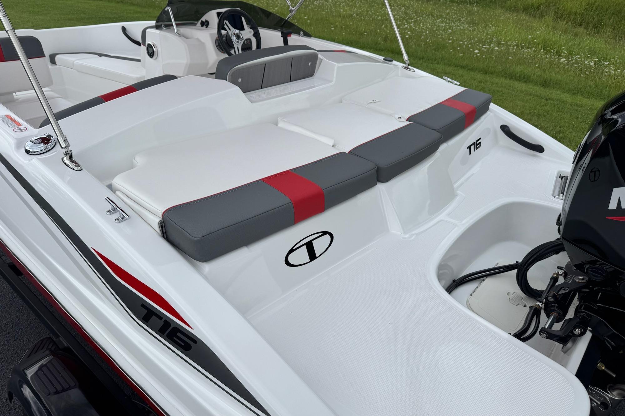2026 Tahoe T16 boat interior with red and gray seating, steering wheel, and motor.