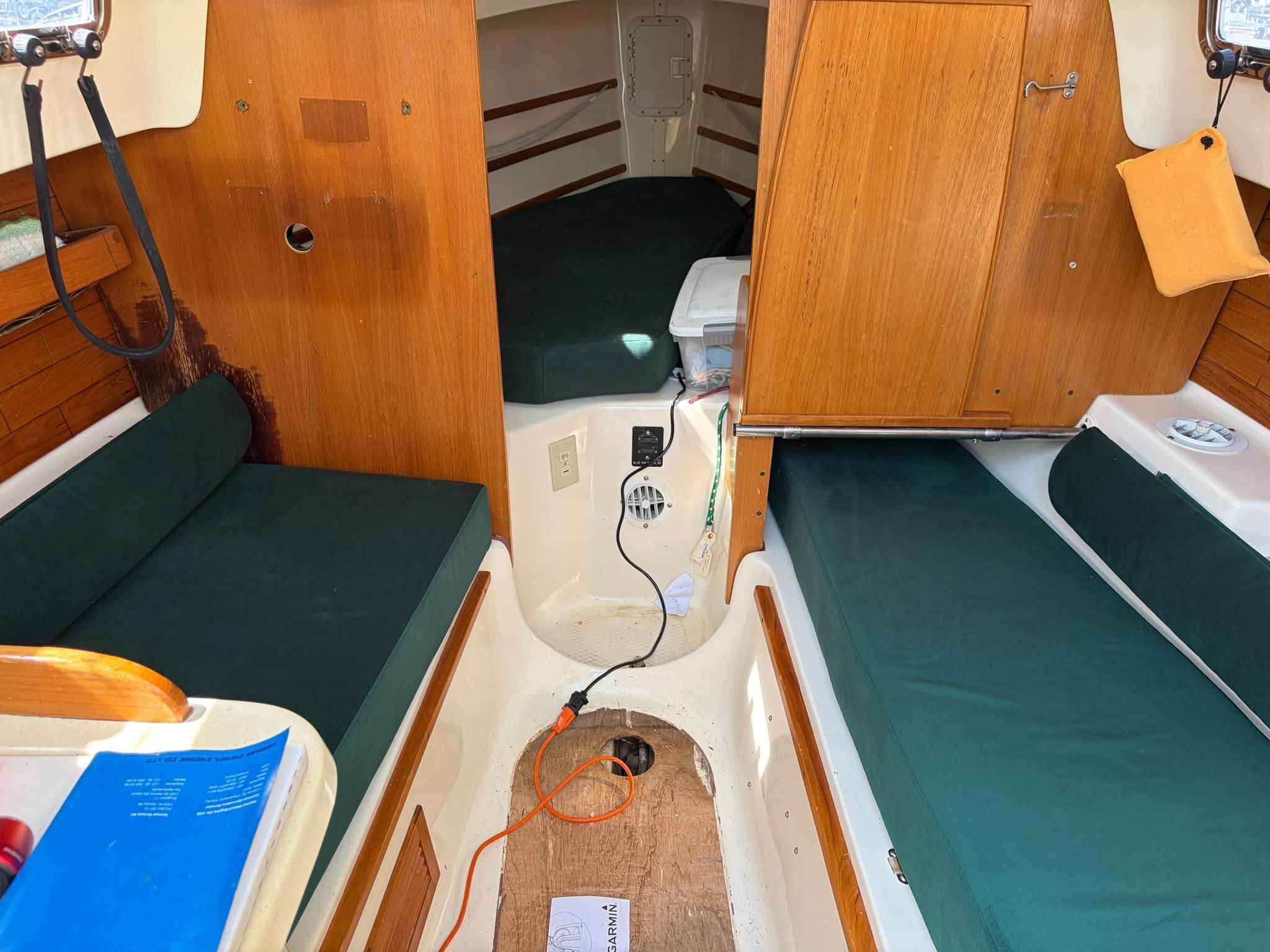 Interior of a 2003 Seaward 25 with green cushions and wooden walls.