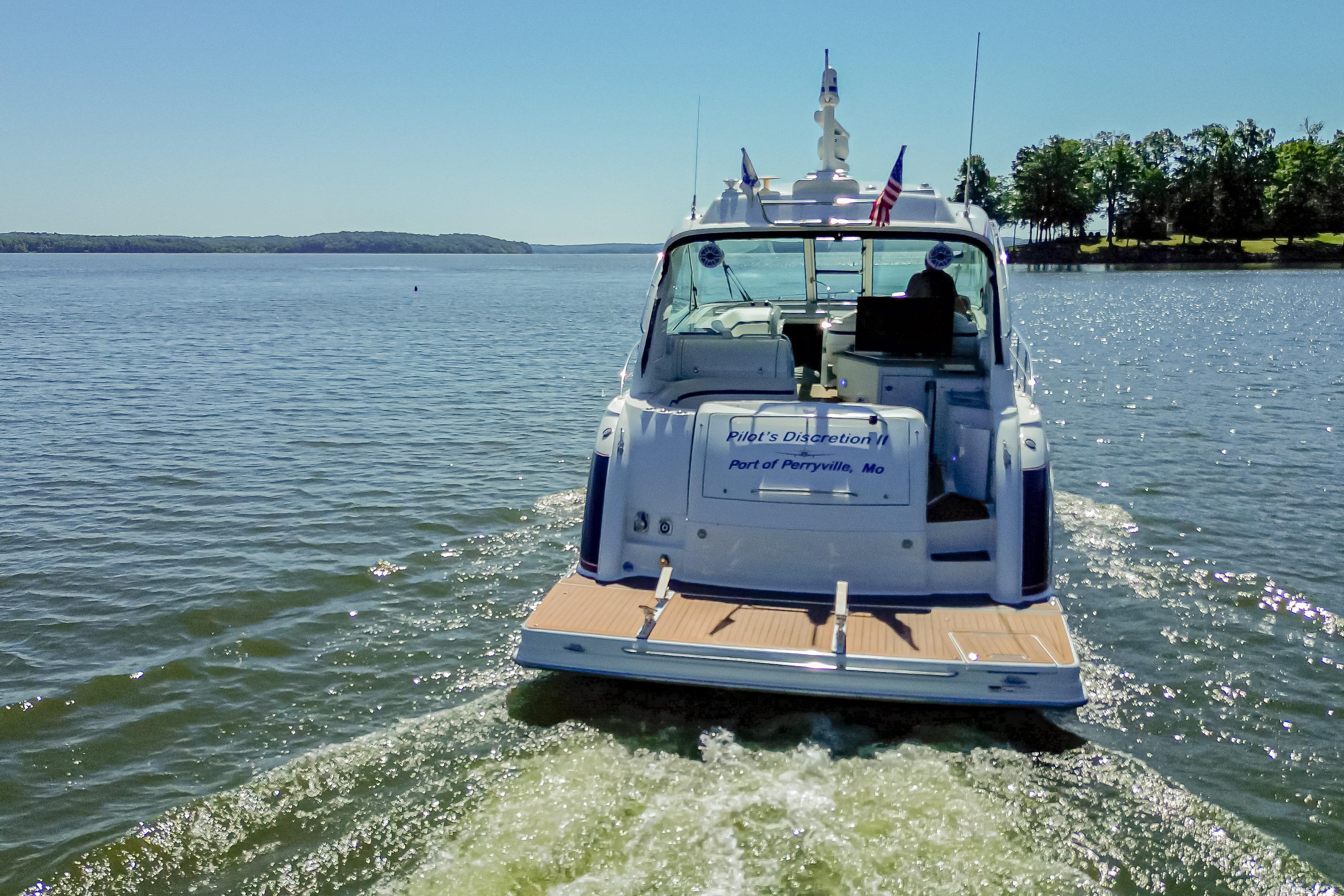 2008 Formula 45 Yacht cruising on a serene lake under a clear blue sky.