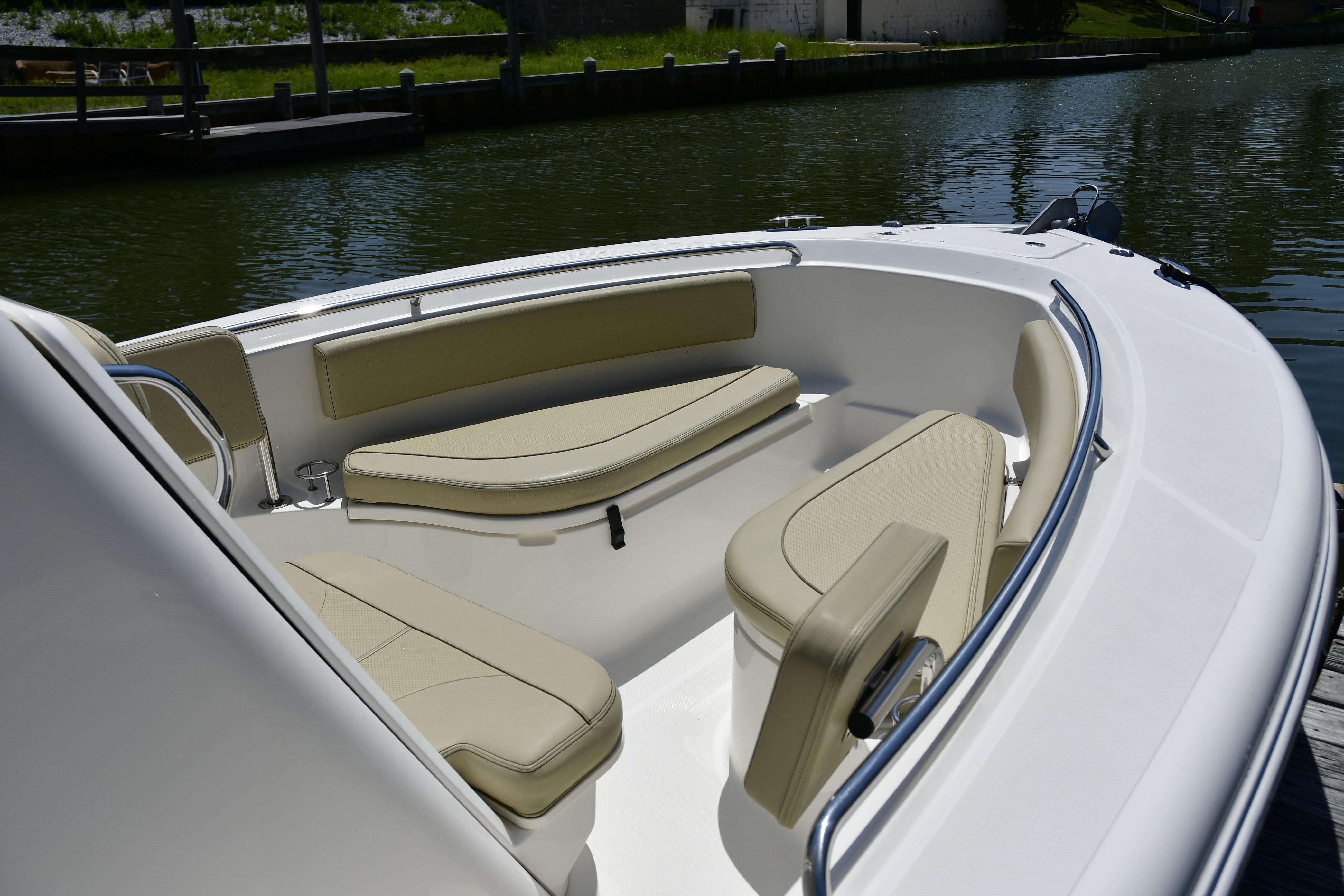 2020 Pursuit C 238 Center Console boat with beige seating, docked on calm water.