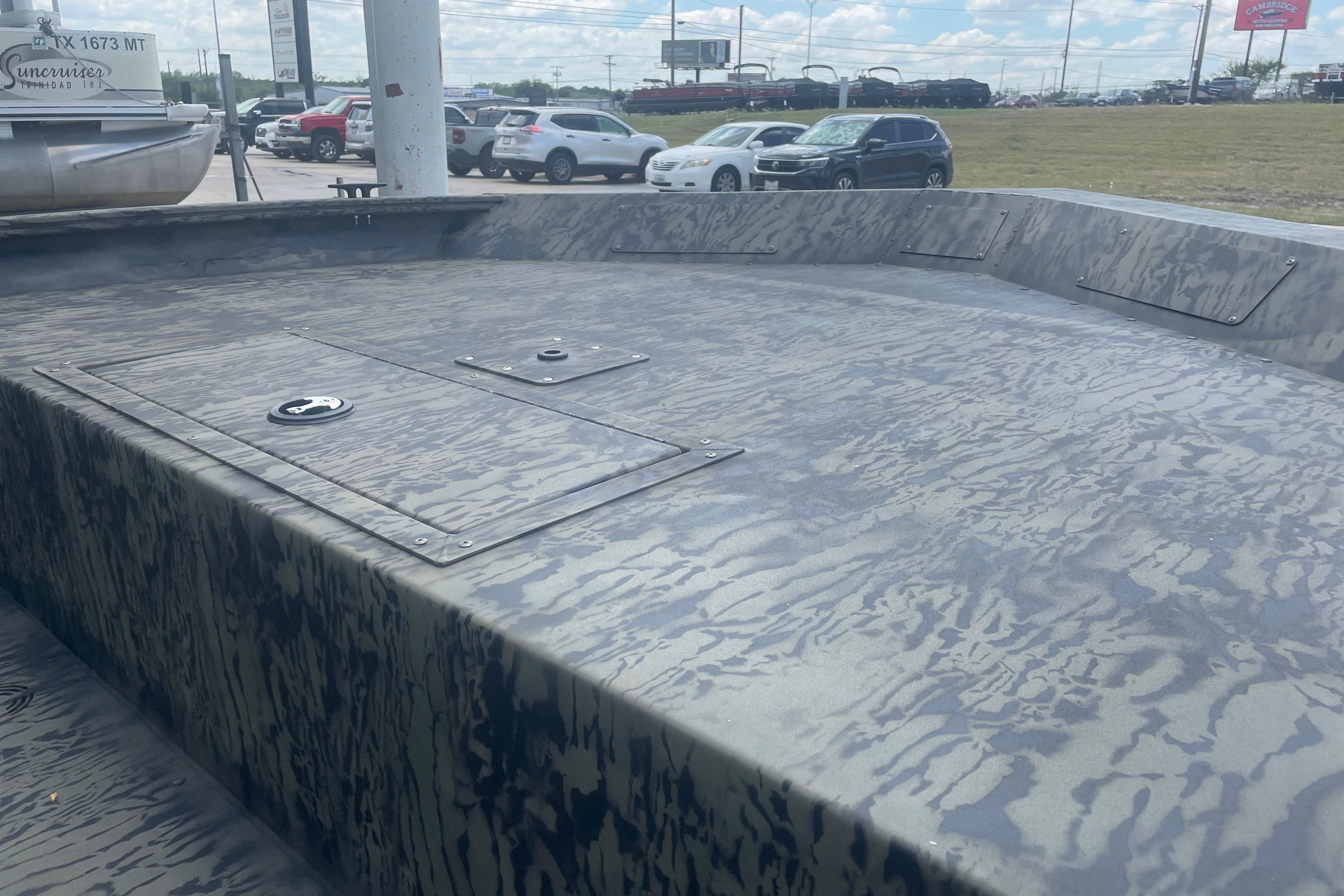 2026 Tracker Grizzly 1860 Utility boat with camouflage pattern, parked outdoors.