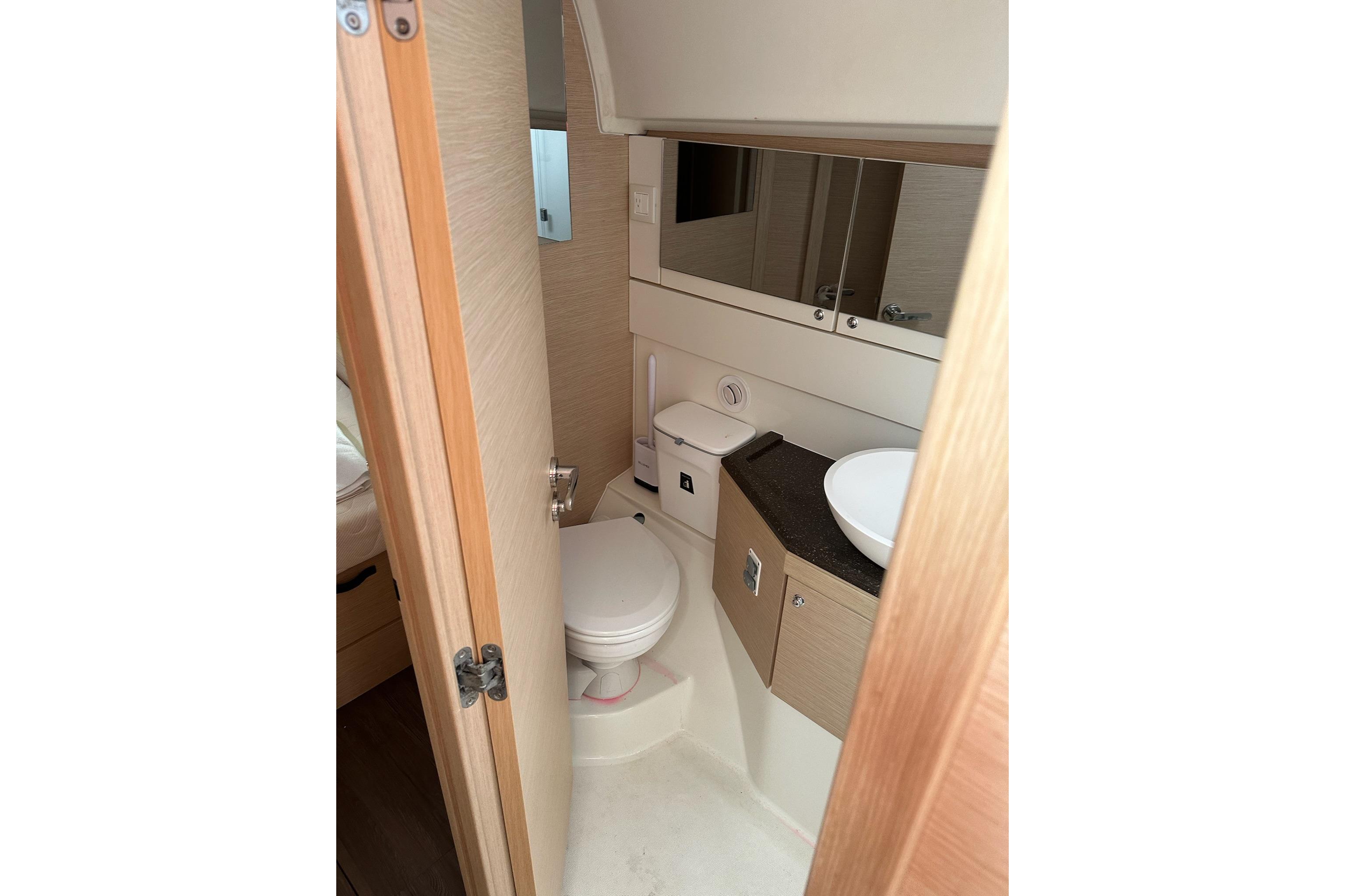 Bathroom interior of 2018 Jeanneau 51 yacht, featuring modern fixtures and wood accents.
