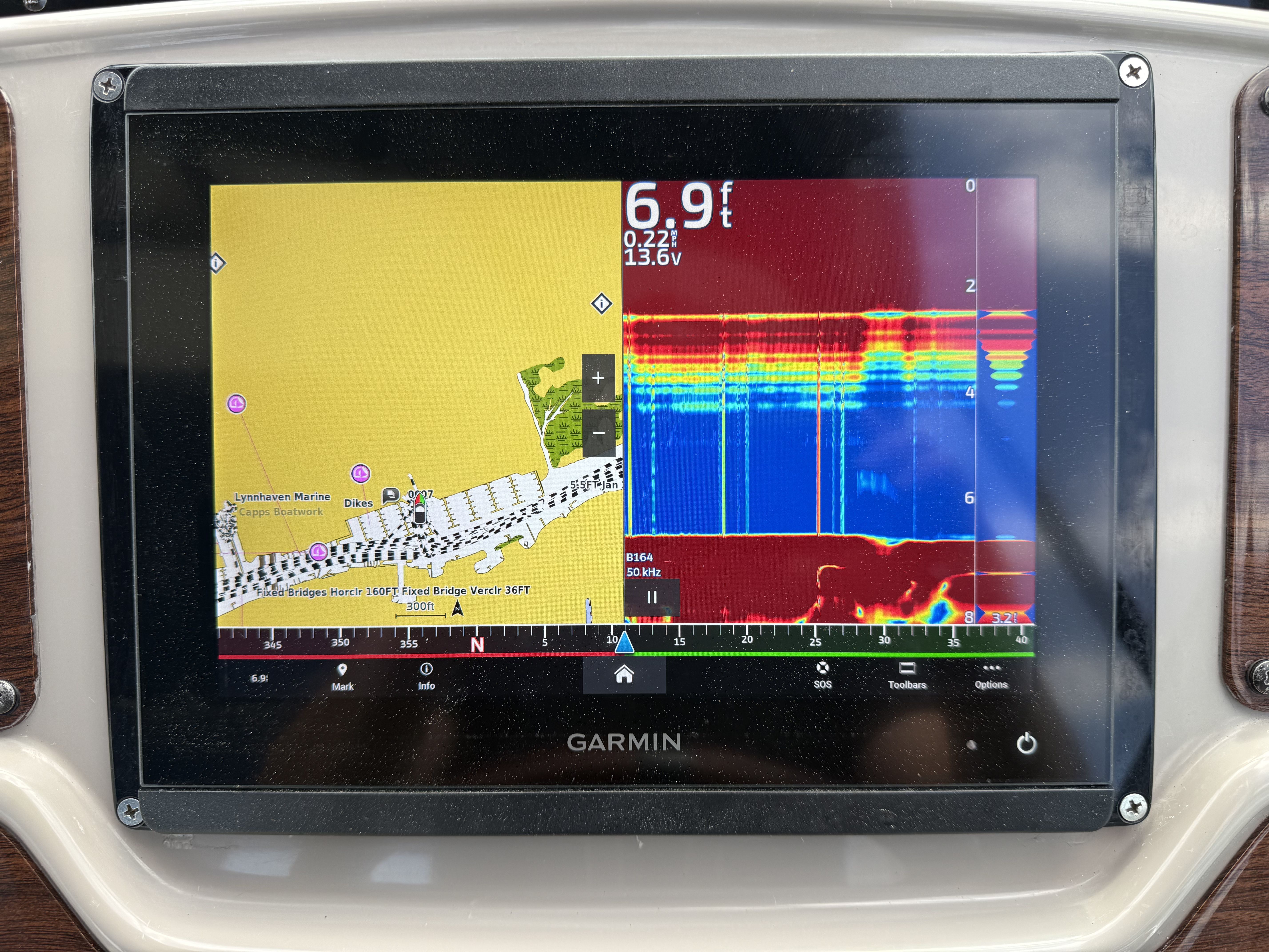 A Garmin fishfinder displaying depth and chart information, mounted on a boat.