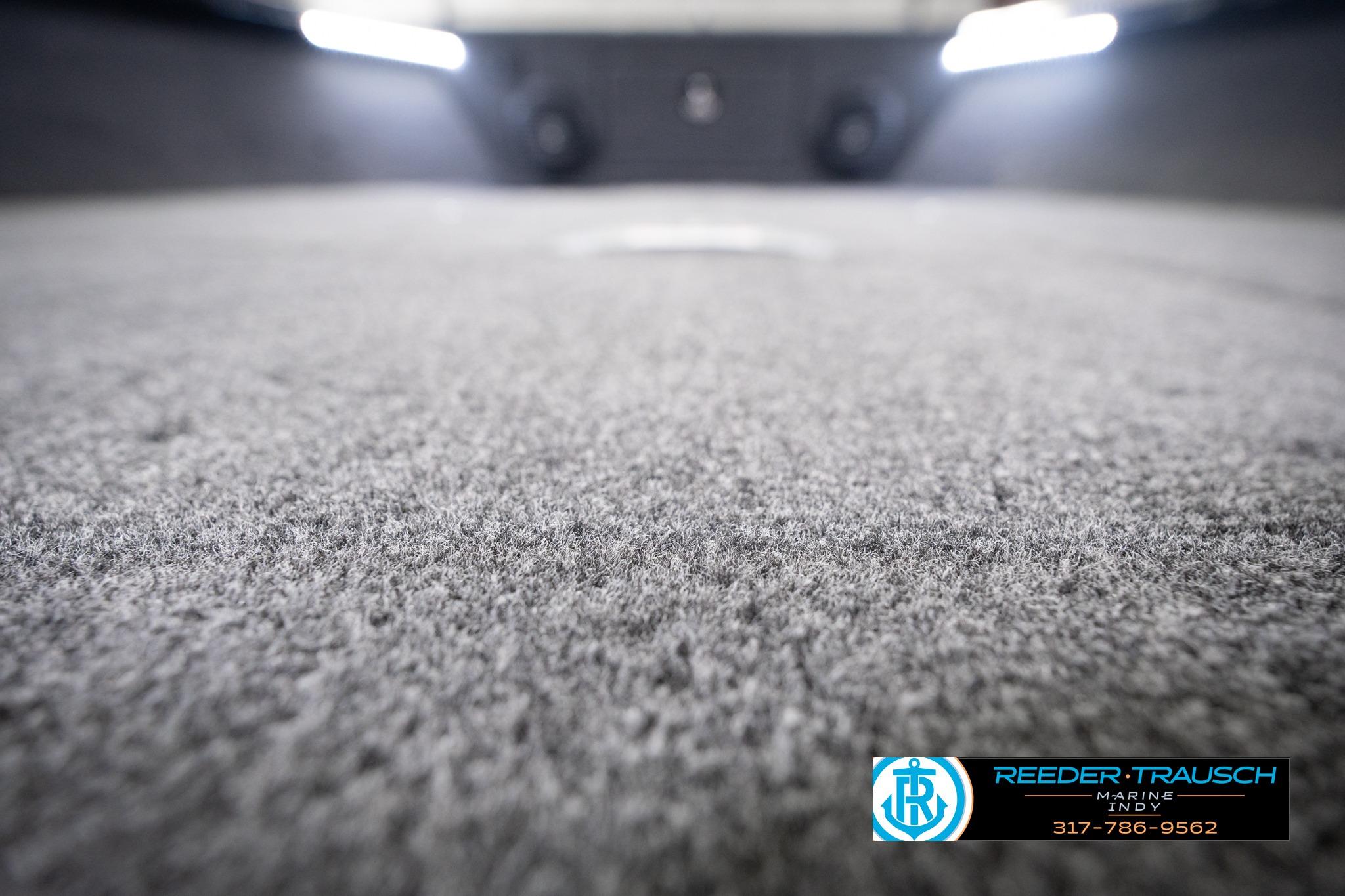Carpeted interior of 2026 Lund 1775 Impact XS SS boat, with logo and contact details.