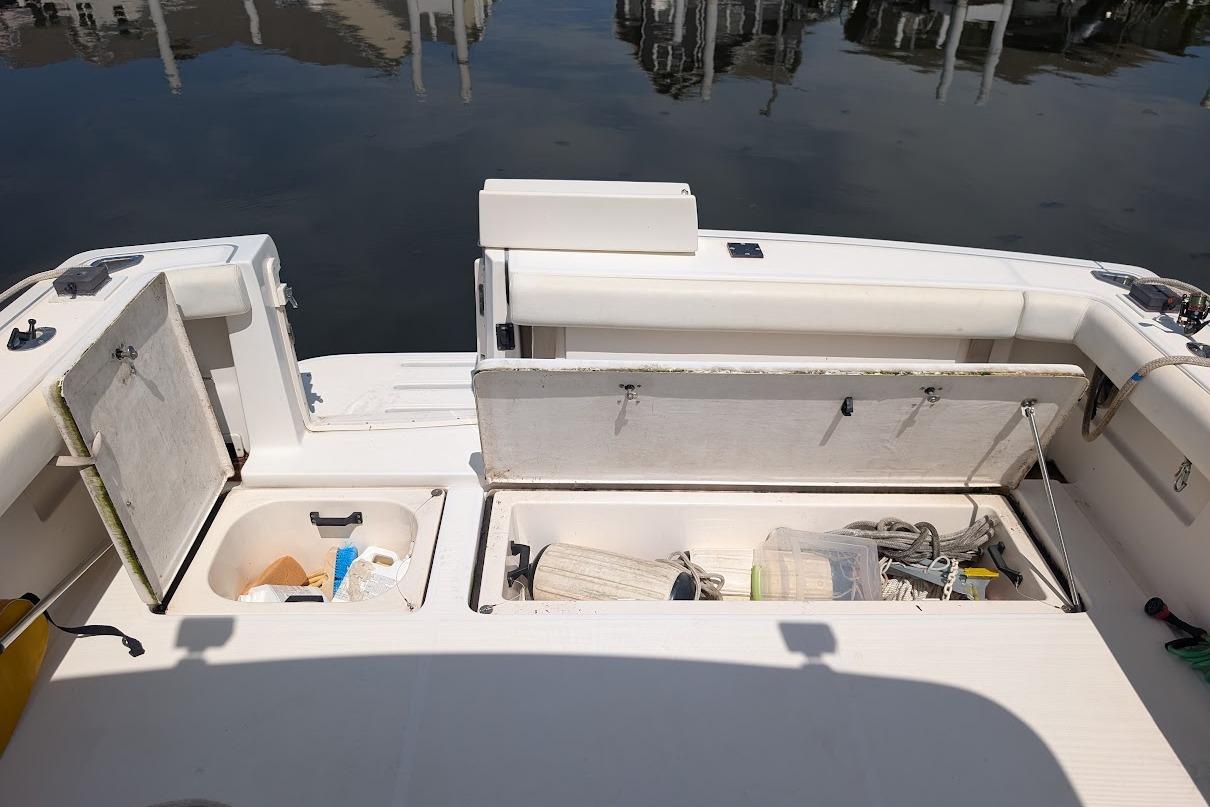2000 Pursuit 3400 Express boat deck with open storage compartments and equipment.