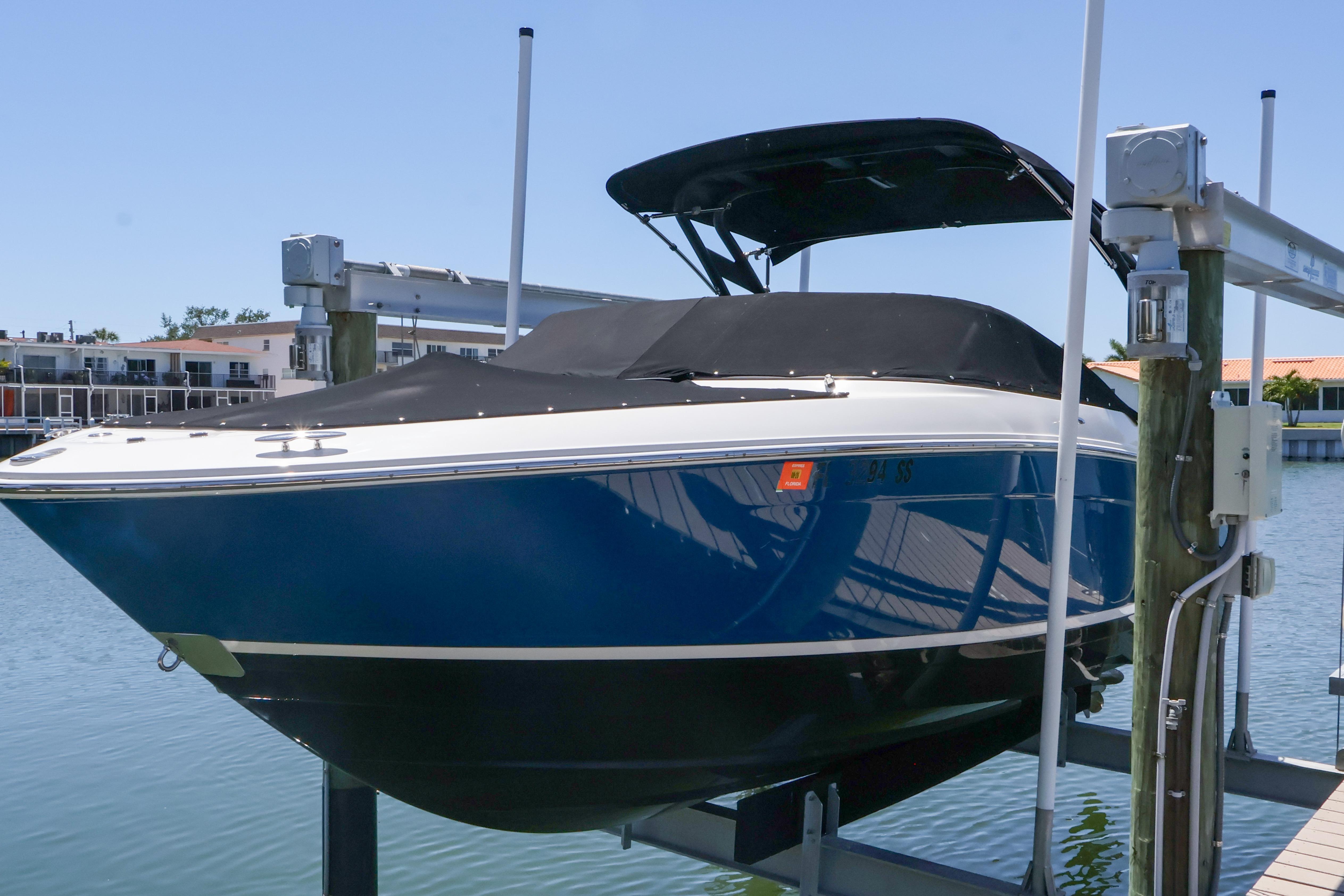 2020 Regal LX4 boat on lift, blue hull, covered, dockside view.