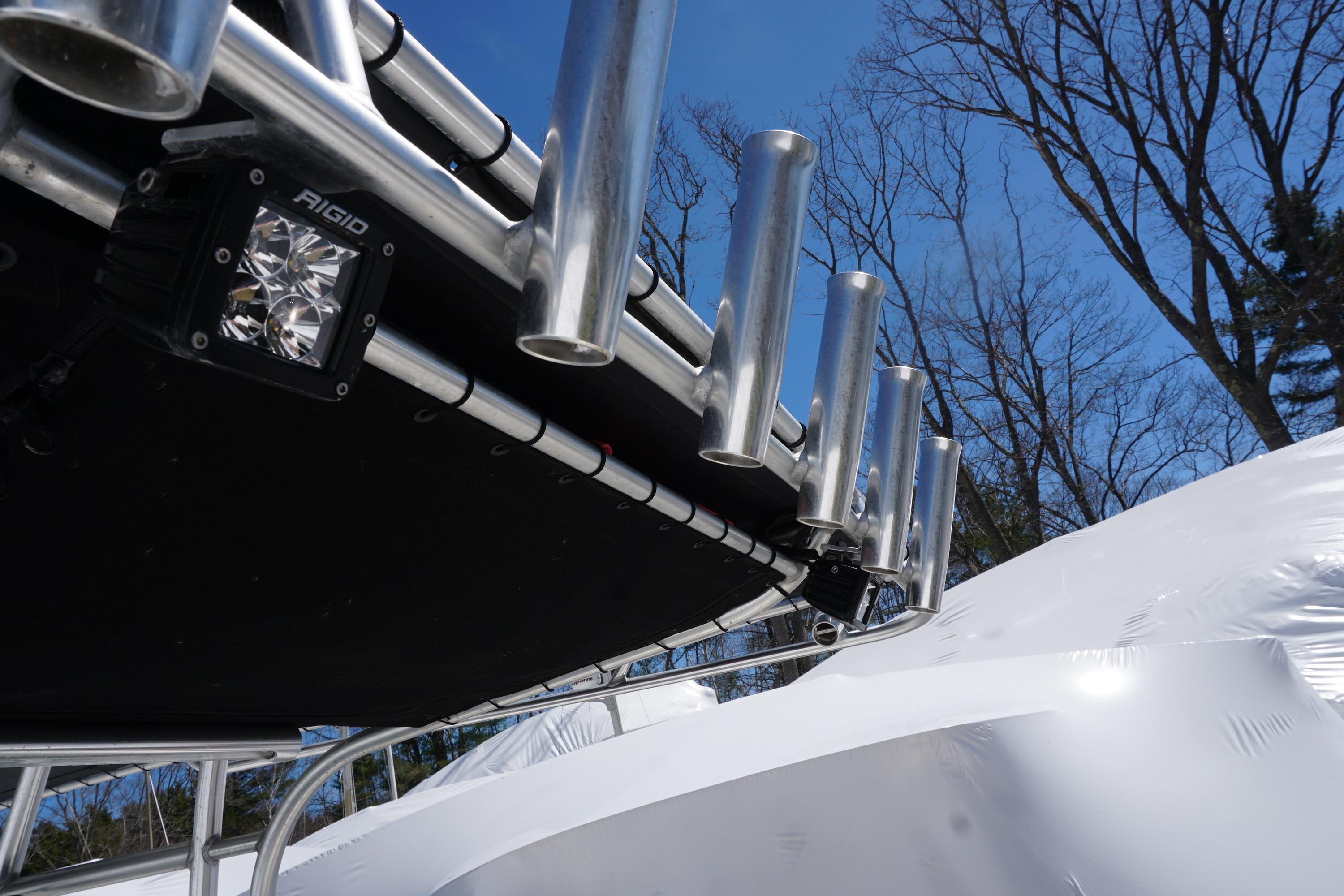 2012 Sailfish 2380 CC boat with rod holders and Rigid LED light, under clear blue sky.