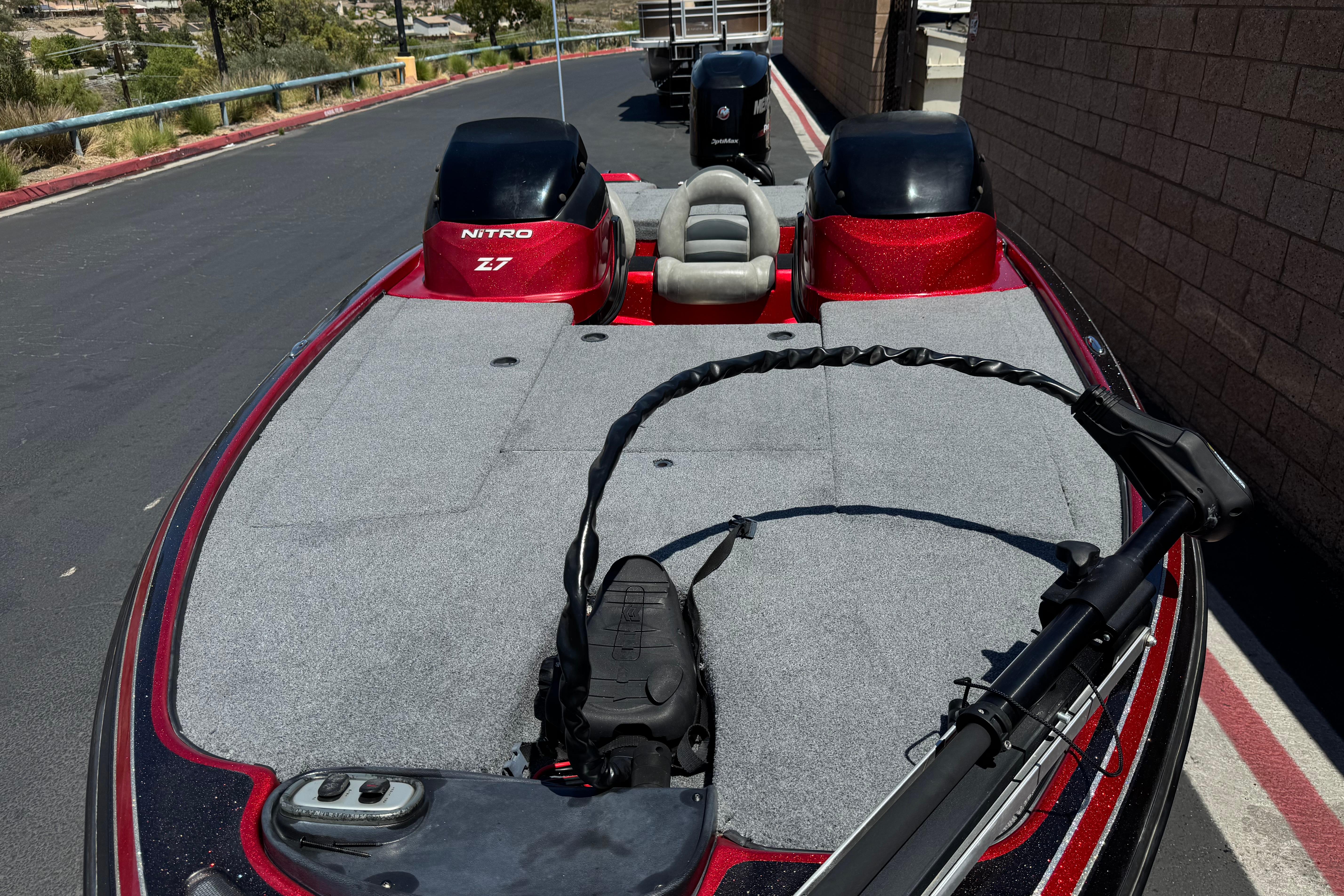 2012 Nitro Z-7 boat with dual engines and spacious deck, parked on a paved road.