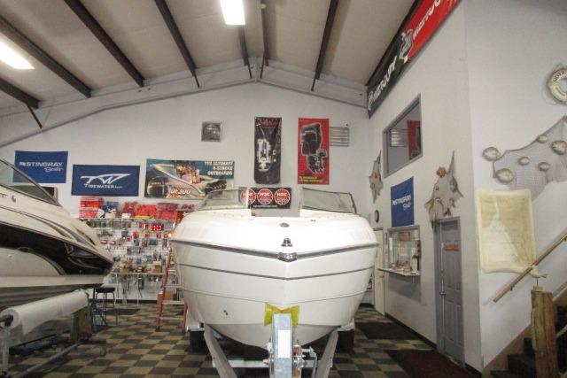 2004 Stingray 240 LR boat displayed in a showroom with nautical decor.