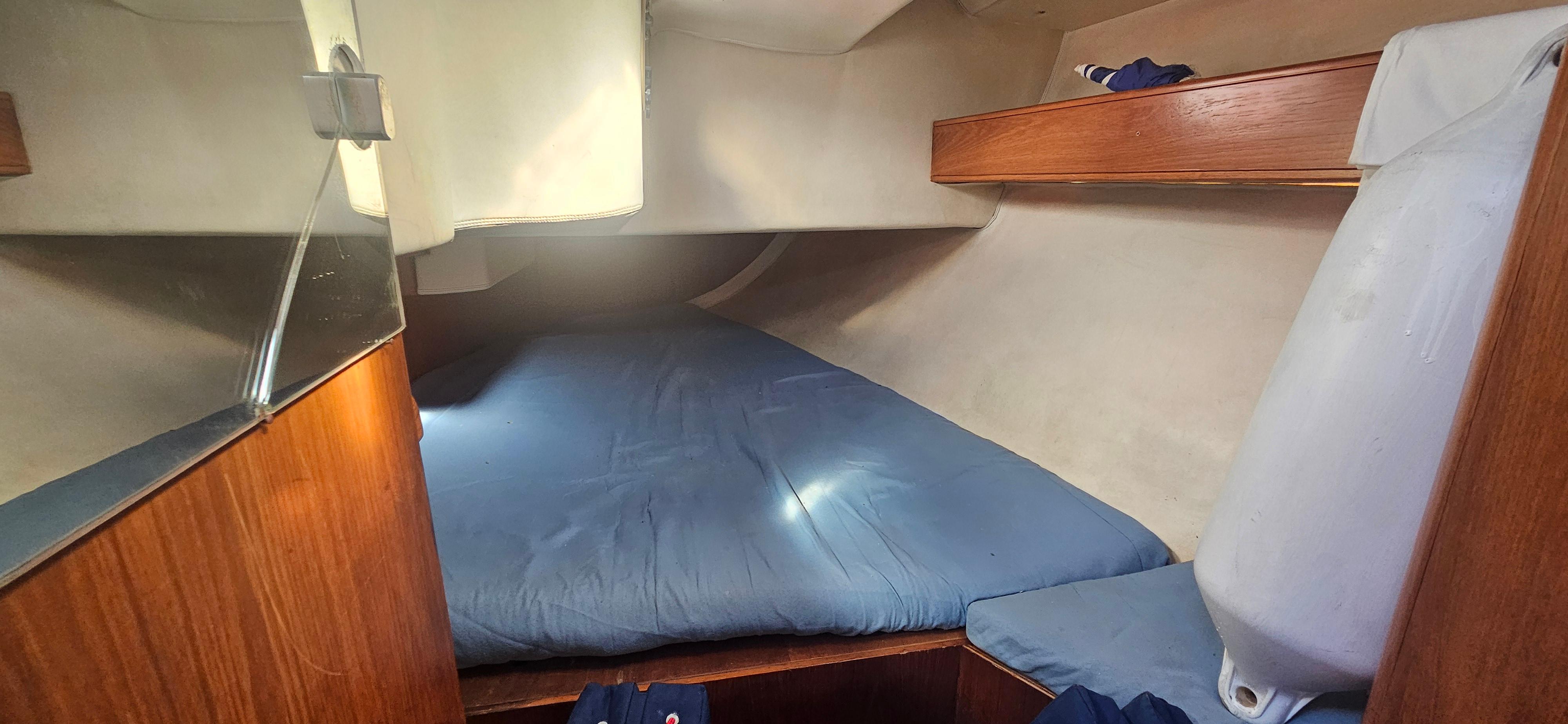 Cozy cabin interior of 1996 Gib'Sea 334 sailboat with blue bedding.