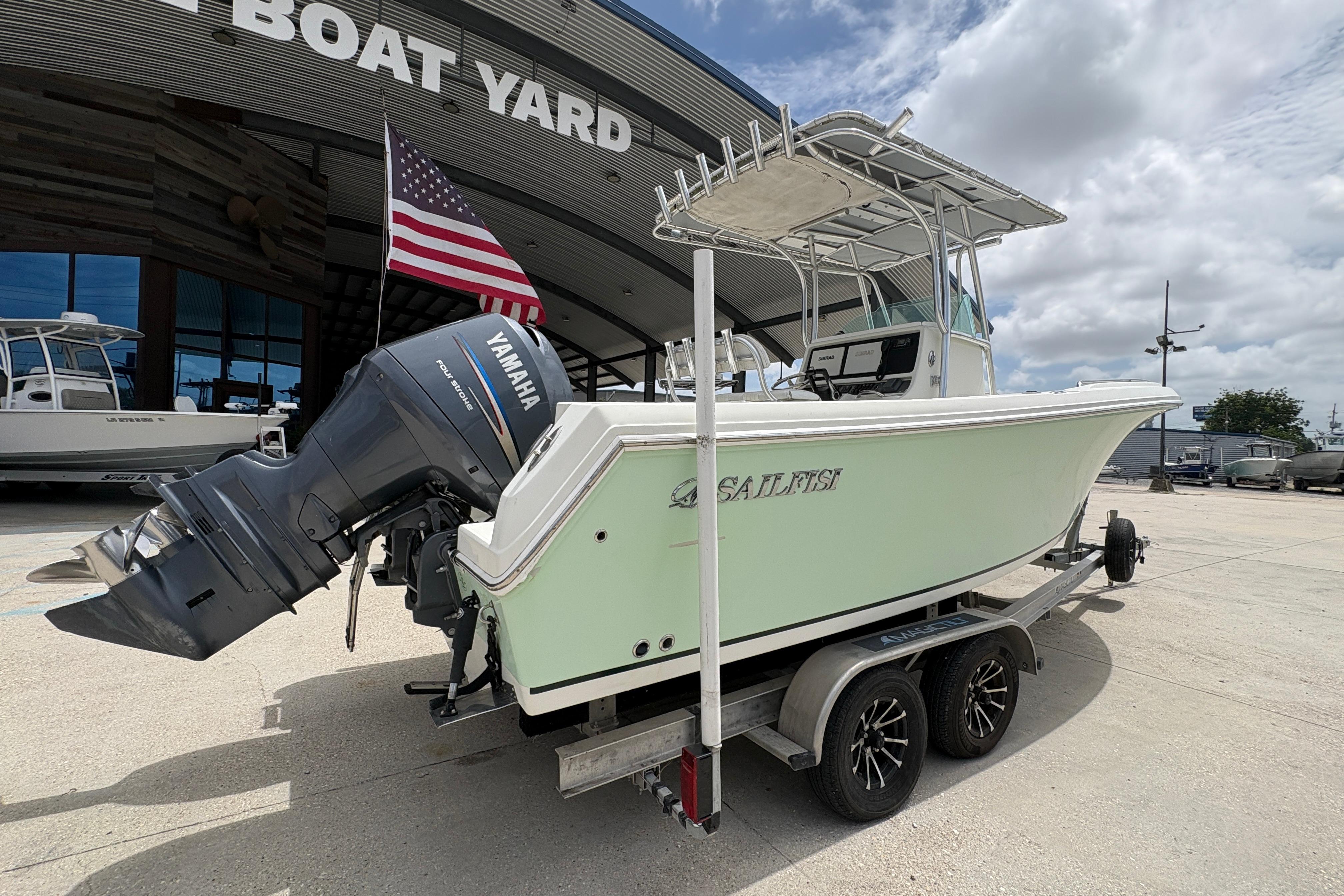2006 Sail Faish 2360 boat with Yamaha engine at boat yard, American flag displayed.