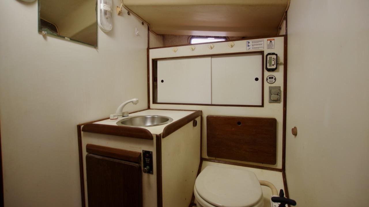 1981 Morgan Out Island 41 yacht bathroom with sink, toilet, and storage cabinets.