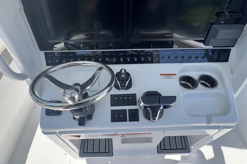 2026 Sea Hunt Gamefish 30 helm with steering wheel, controls, and cup holders.