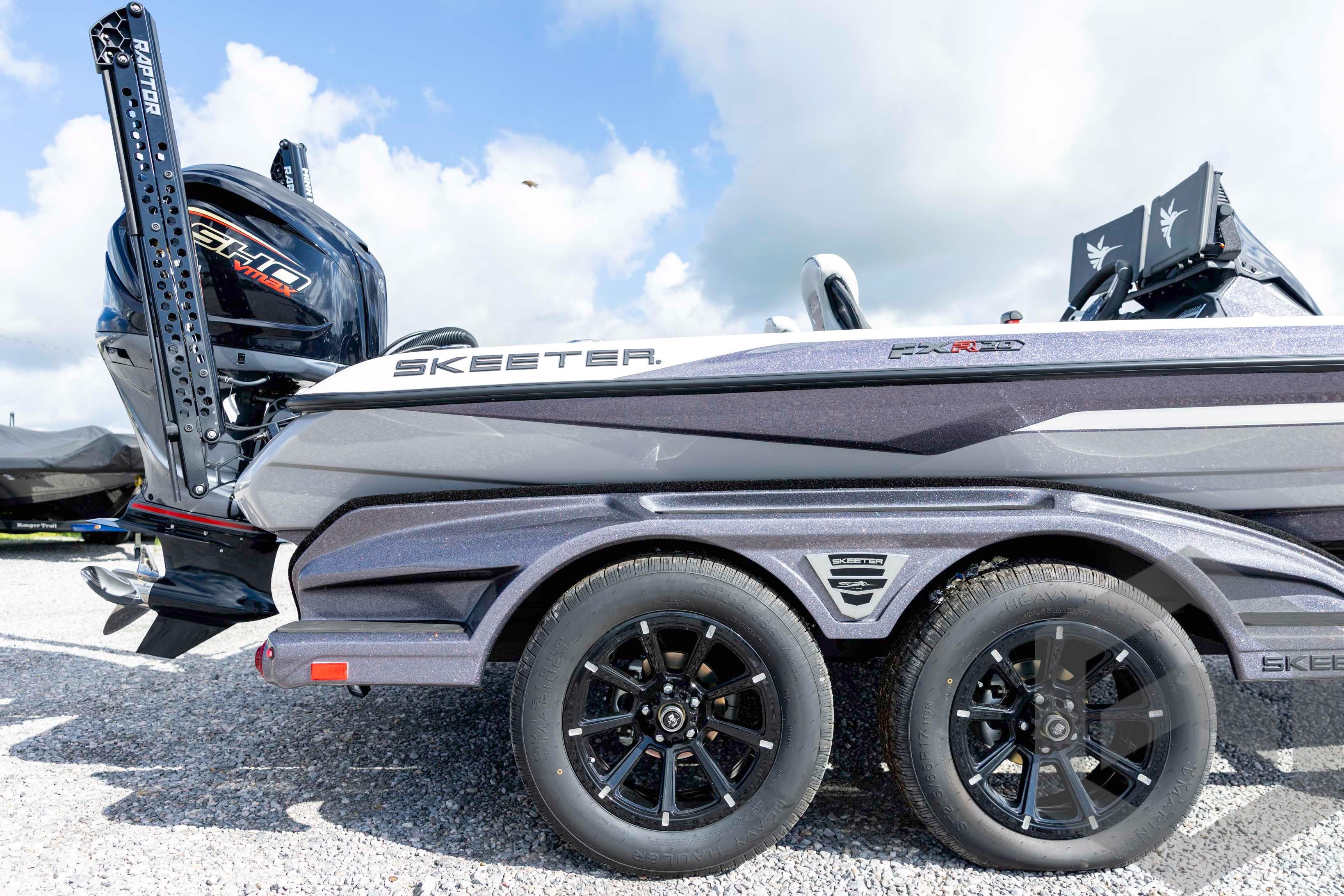 2026 Skeeter FXR20 FLEX boat with dual wheels and powerful engine, parked on gravel.
