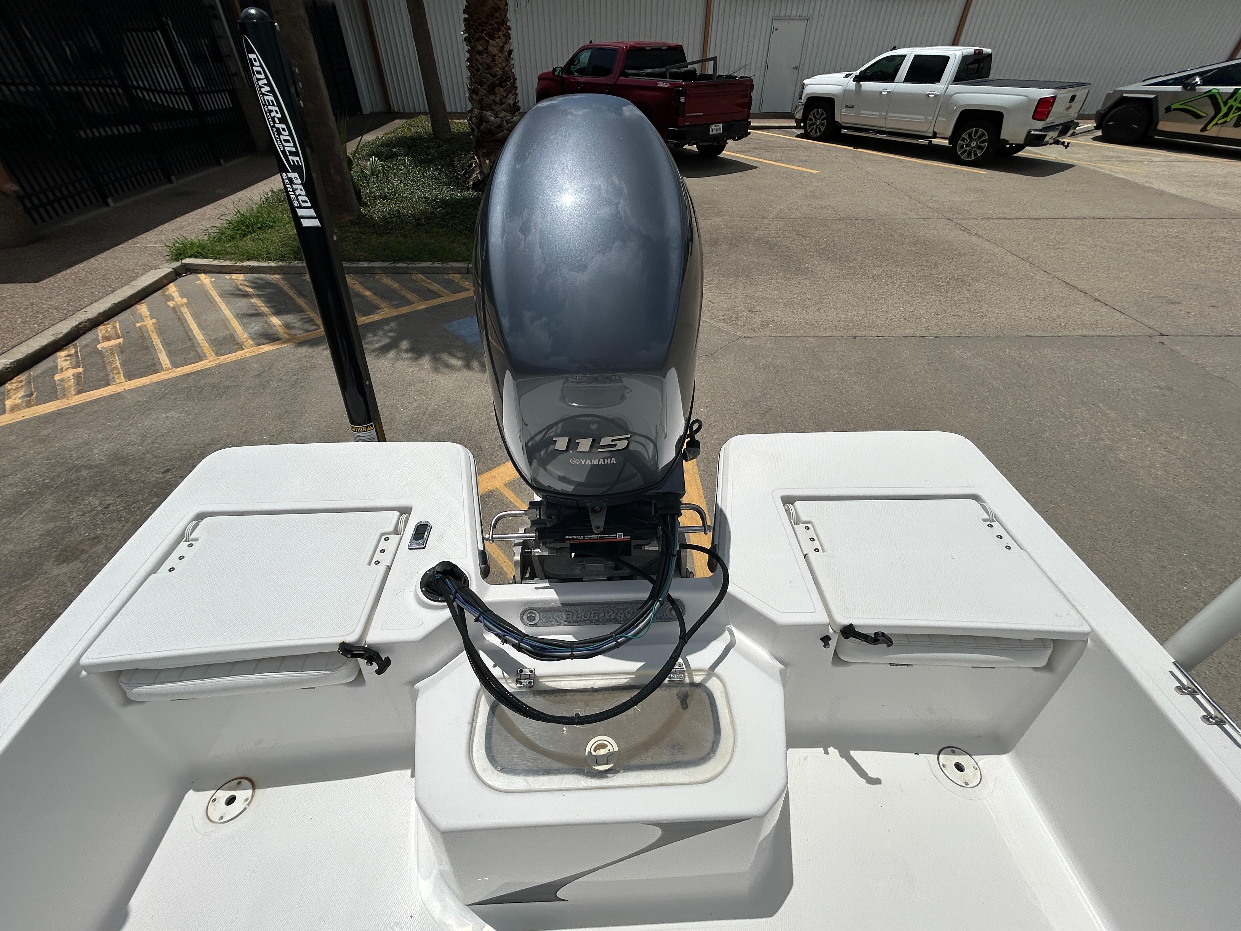 2012 Blue Wave 1900 STL boat with Yamaha 115 engine in parking lot.