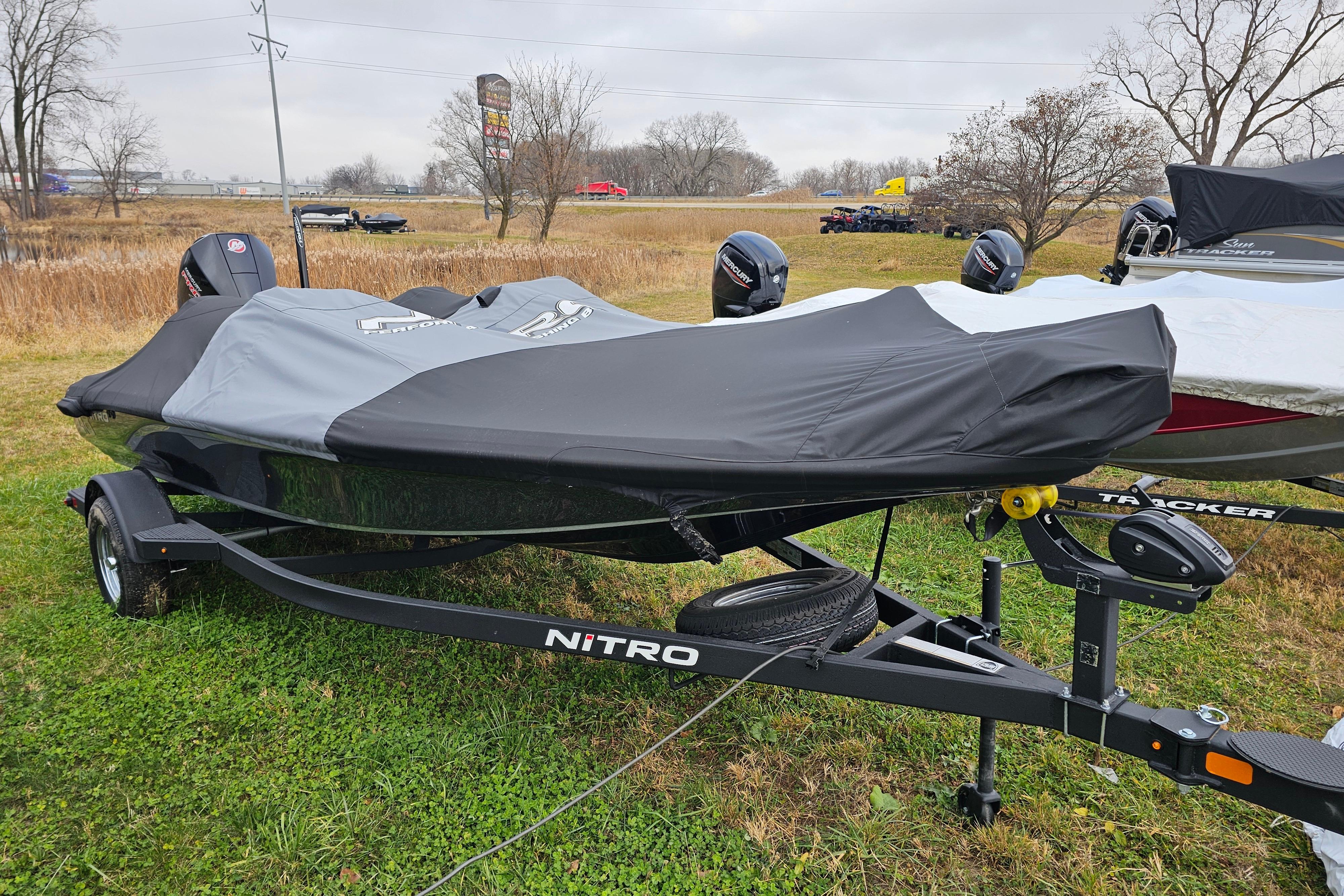 2025 Nitro Z18 Pro boat covered on trailer, parked on grassy area.