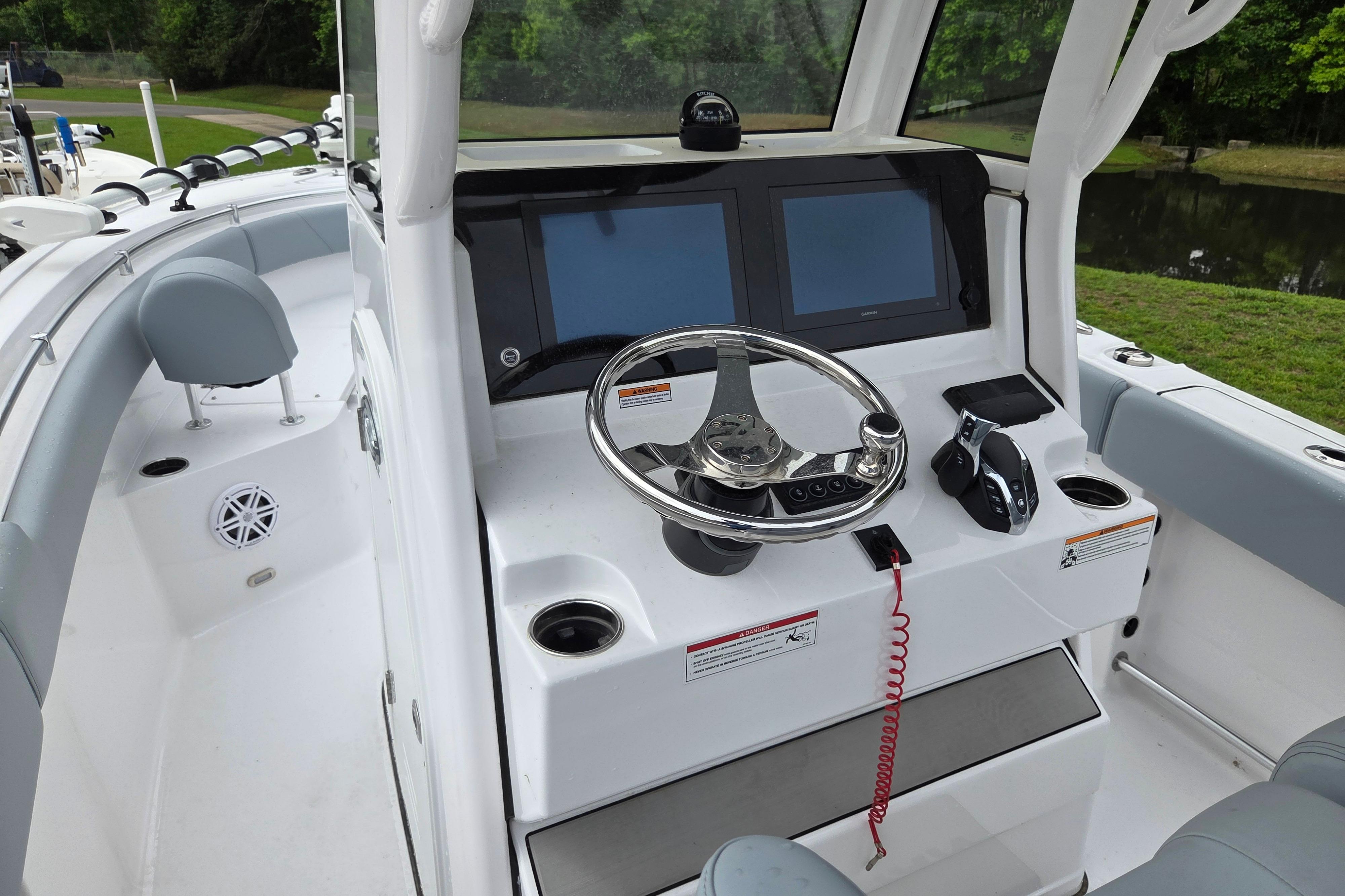 2026 Sportsman Open 232 Center Console boat interior with steering wheel and dual screens.