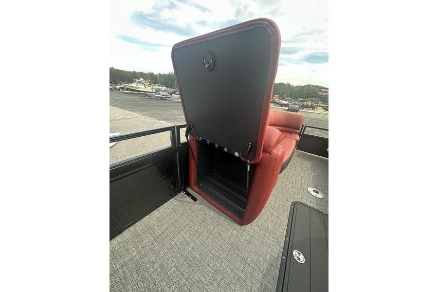 2026 Regency 230 DL boat with open storage compartment and red seating.
