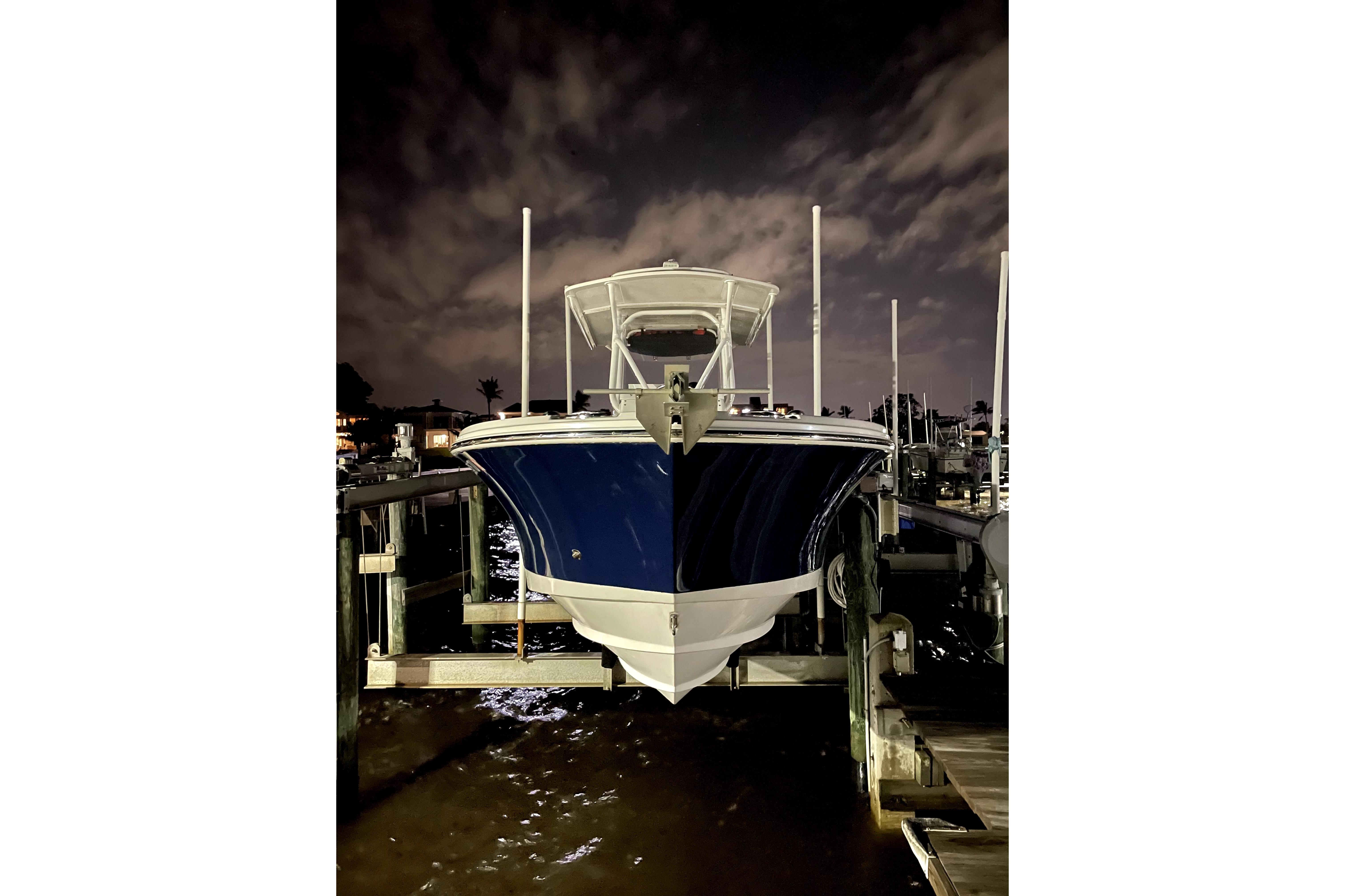 2015 Edgewater 245CC boat docked at night under cloudy sky.