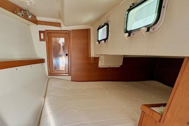 Interior cabin of a 1992 Catalina 34 sailboat with wooden accents and windows.