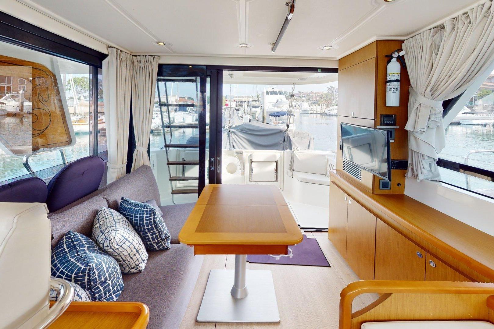Interior of 2021 Beneteau Swift Trawler 35, featuring modern seating and a view of the marina.