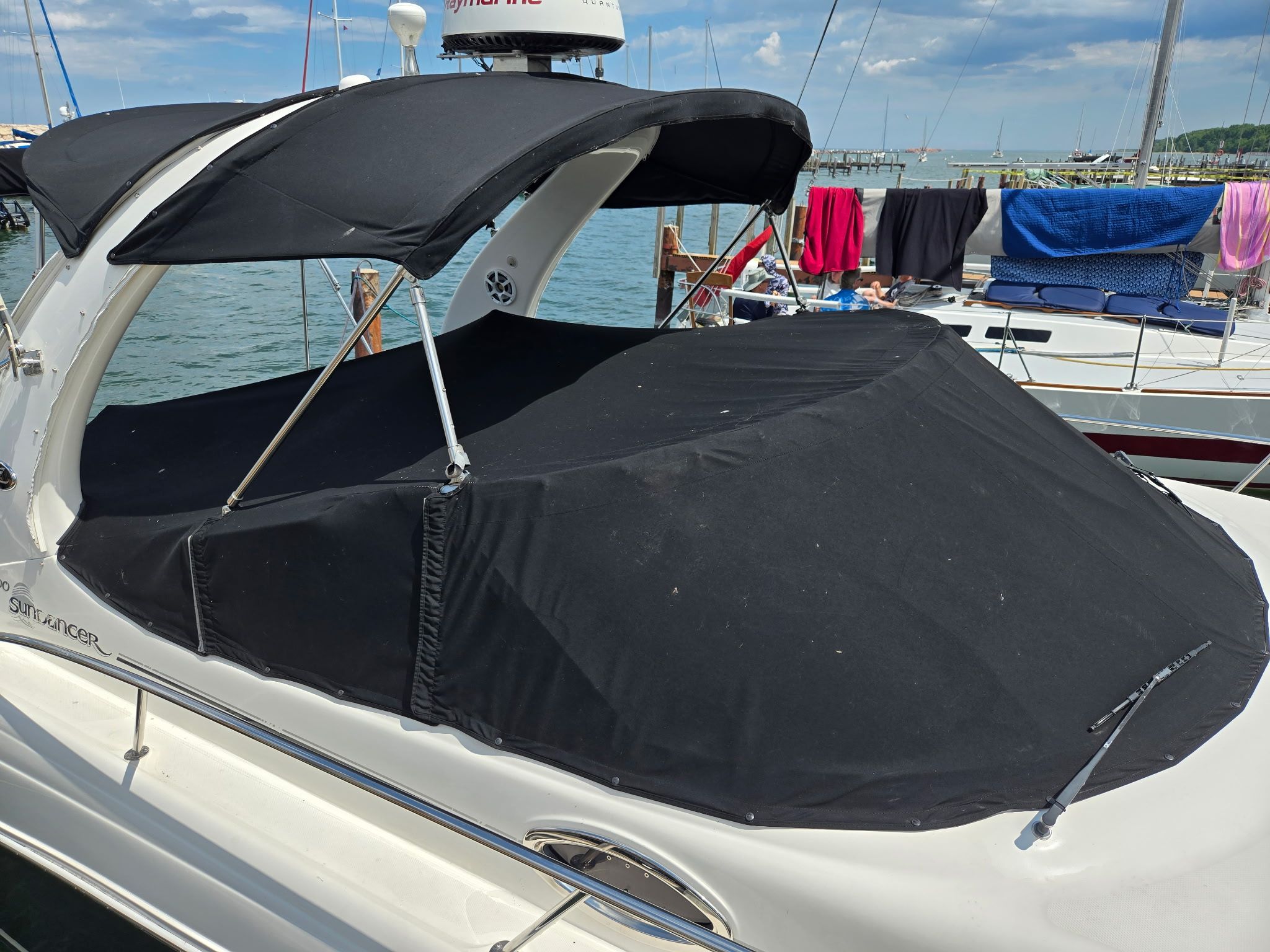A 2006 Sea Ray 300 Sundancer with a black cover docked at the marina.