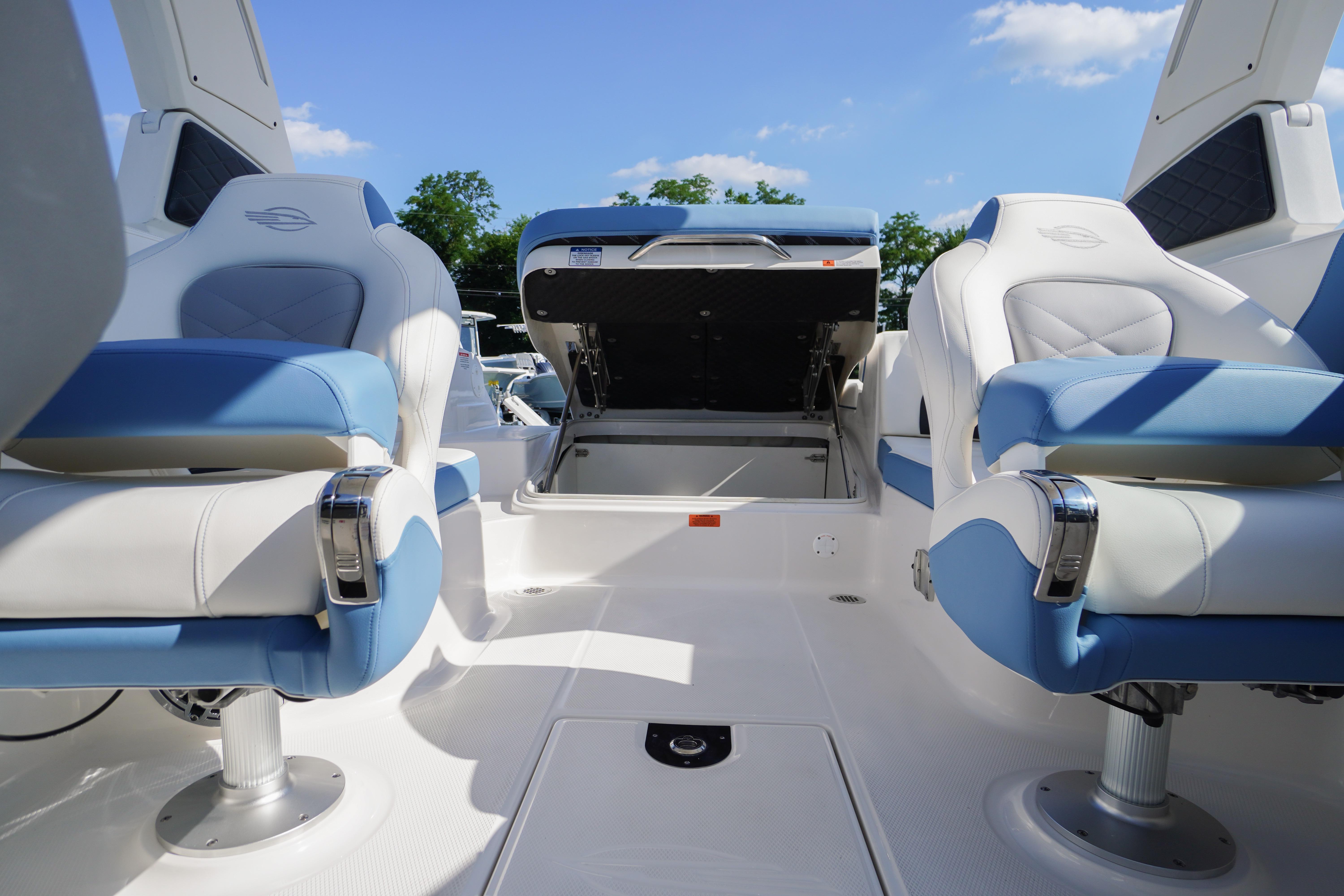 2026 Chaparral 270 OSX boat interior with blue and white seating, open storage compartment.