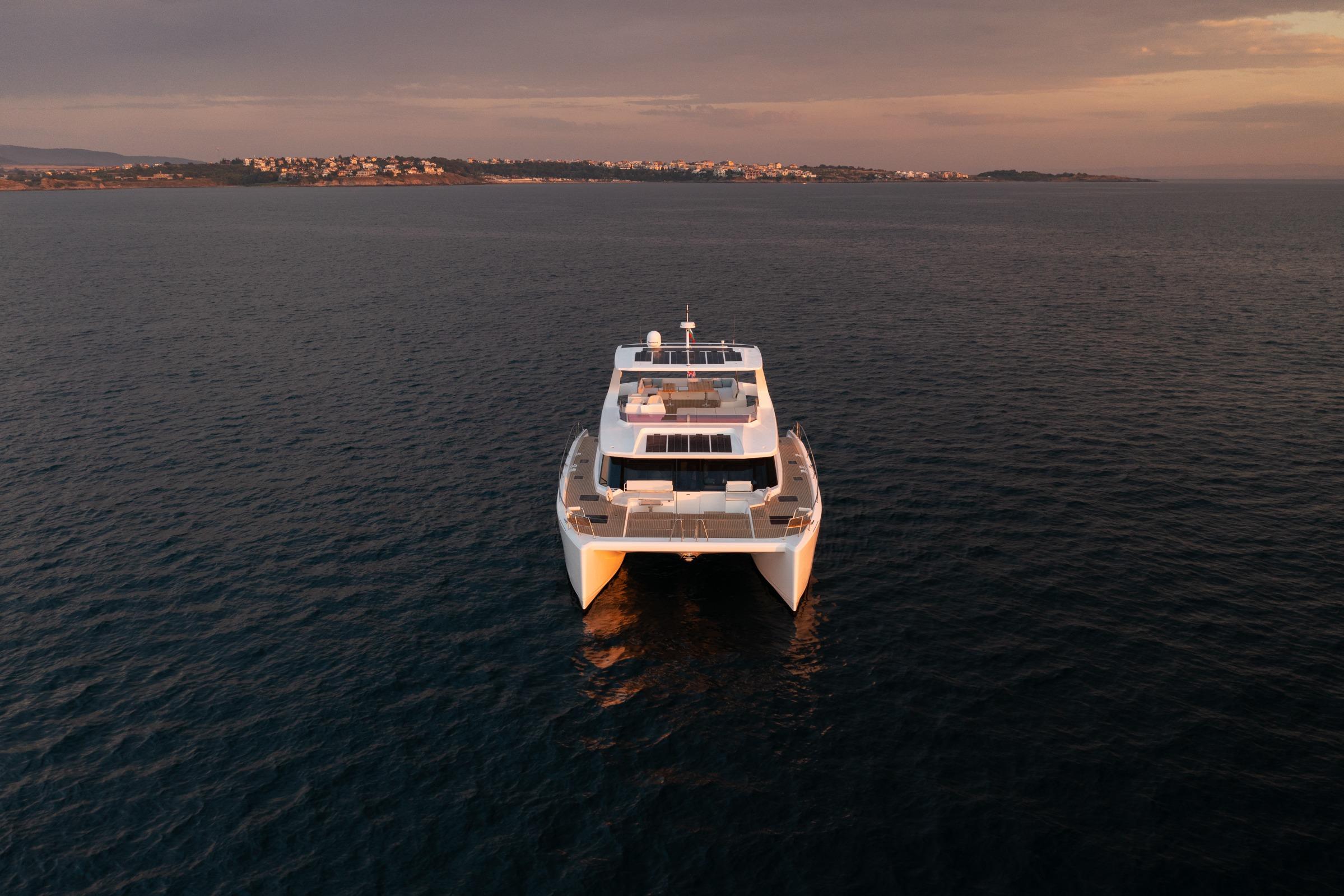Front view of 2025 Custom Omaya 50 Power Catamaran on calm sea at sunset.