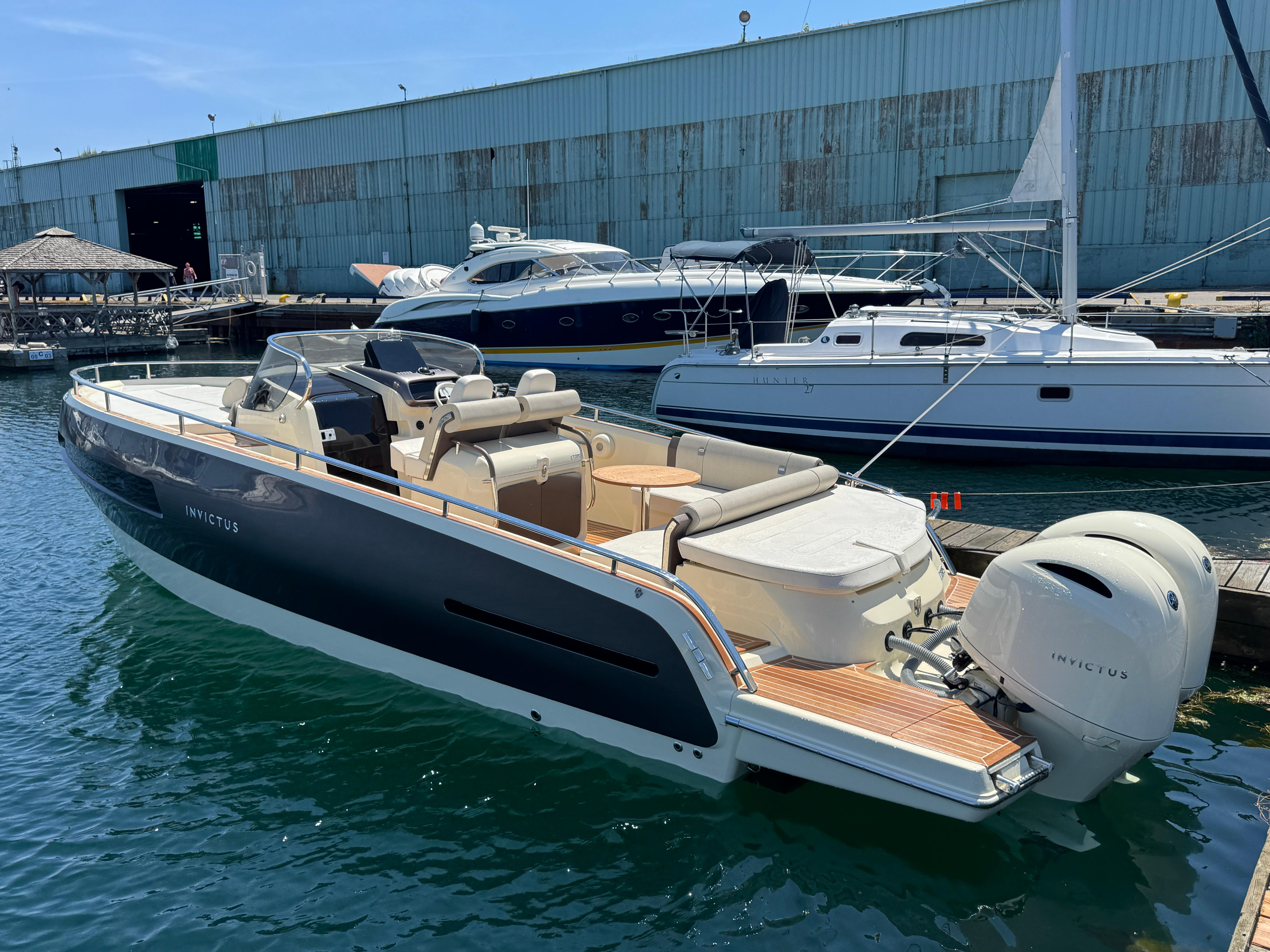 2023 Invictus GT 280S luxury boat docked at marina, showcasing sleek design and powerful engines.
