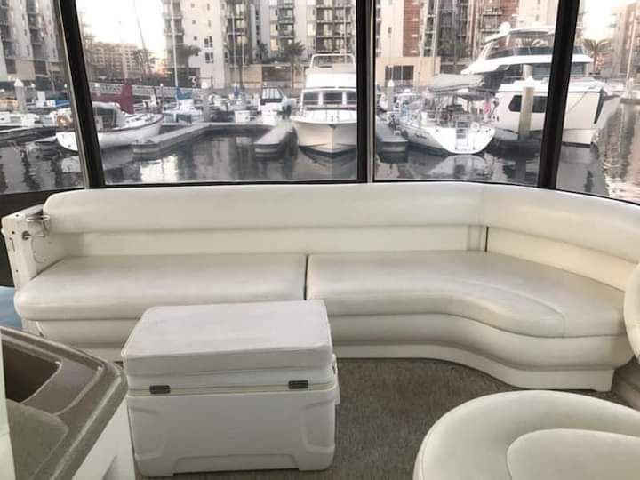 Interior of a 2004 Sea Ray Sedan Bridge with white sofa and marina view.