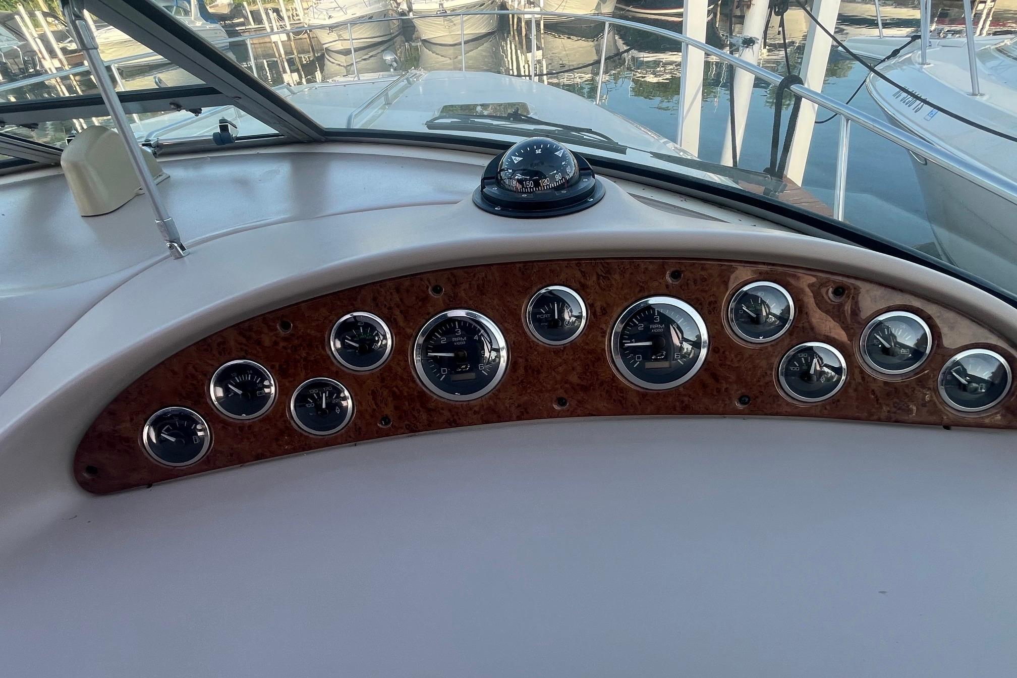 Dashboard of a 2001 Sea Ray 340 Sundancer boat with gauges and compass.