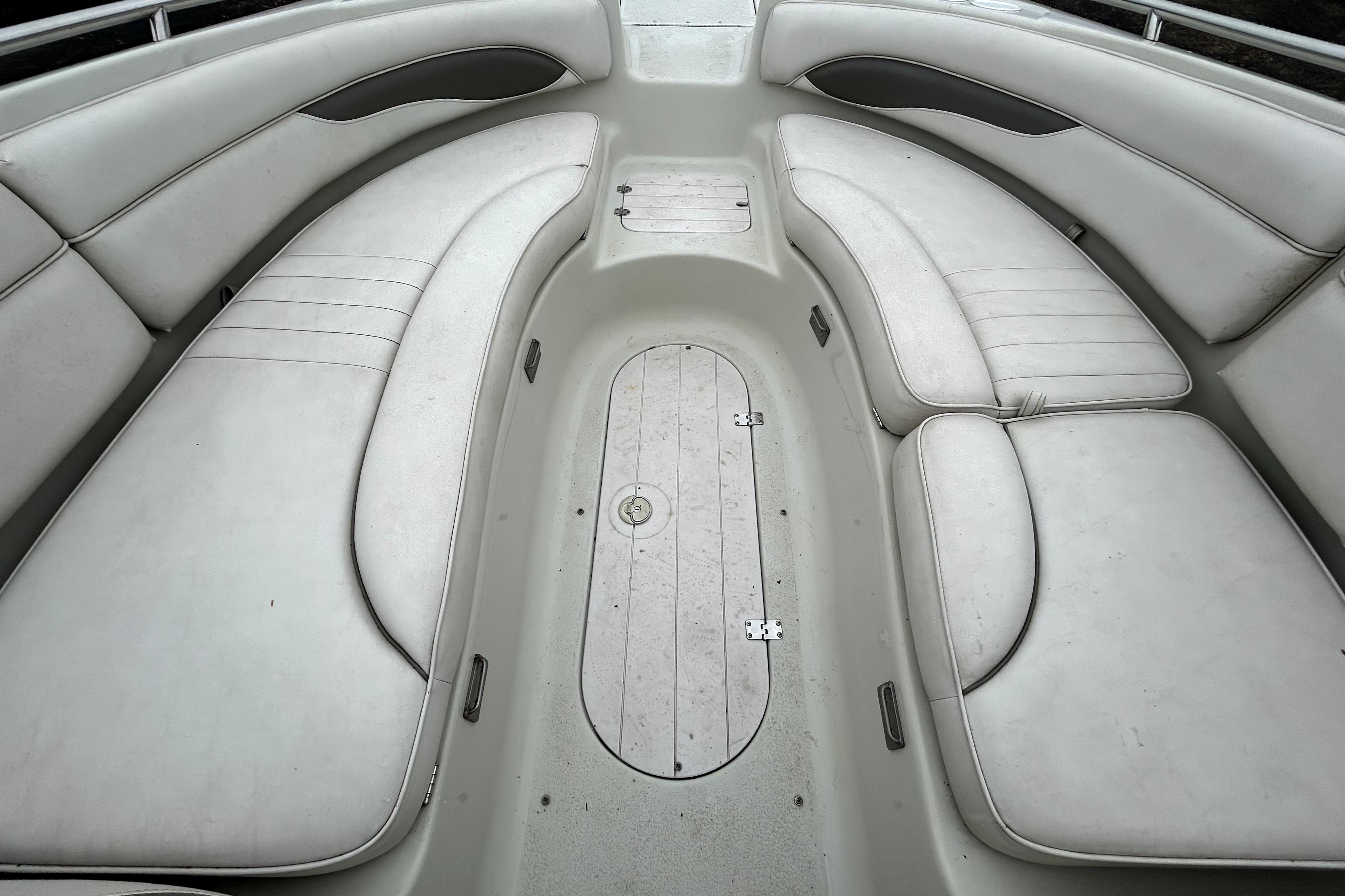 Interior seating of a 2001 Crownline 239 DB boat, featuring white cushioned benches.