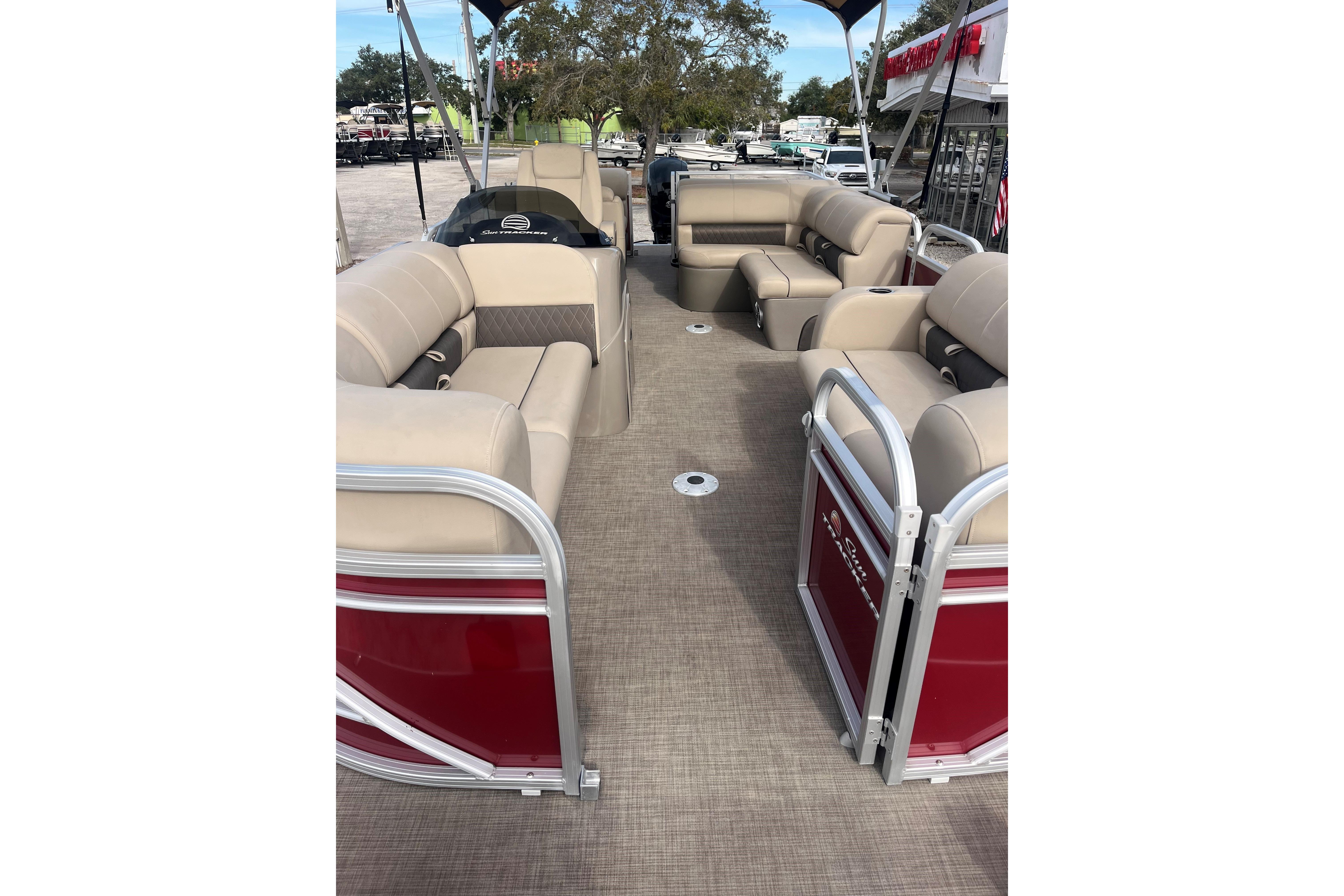 2023 Sun Tracker Party Barge 22 RF DLX interior with beige seating and red accents.