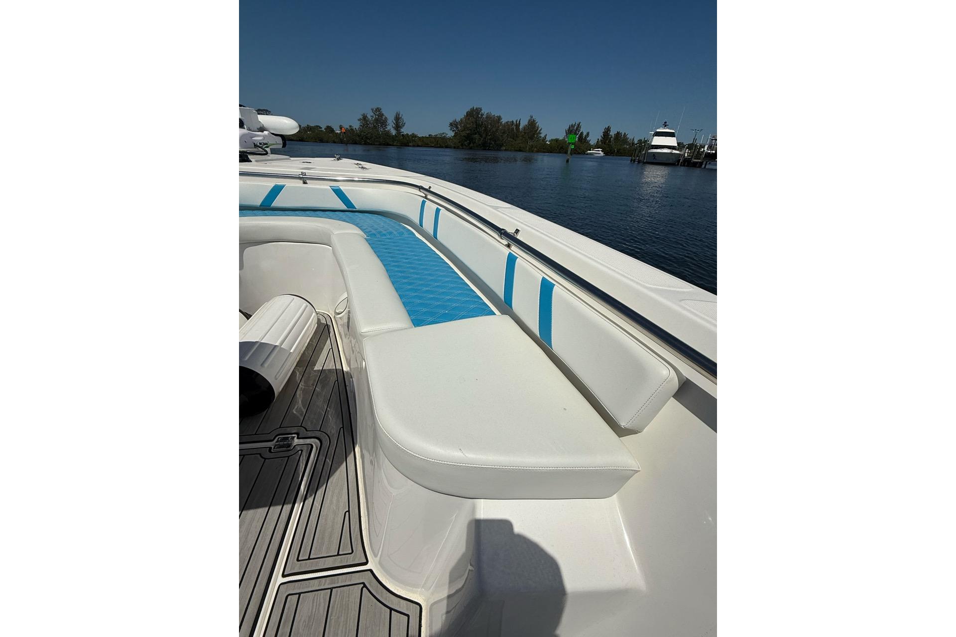 Custom Infusion 34 CC 2021 boat with white and blue seating, docked on a sunny day.