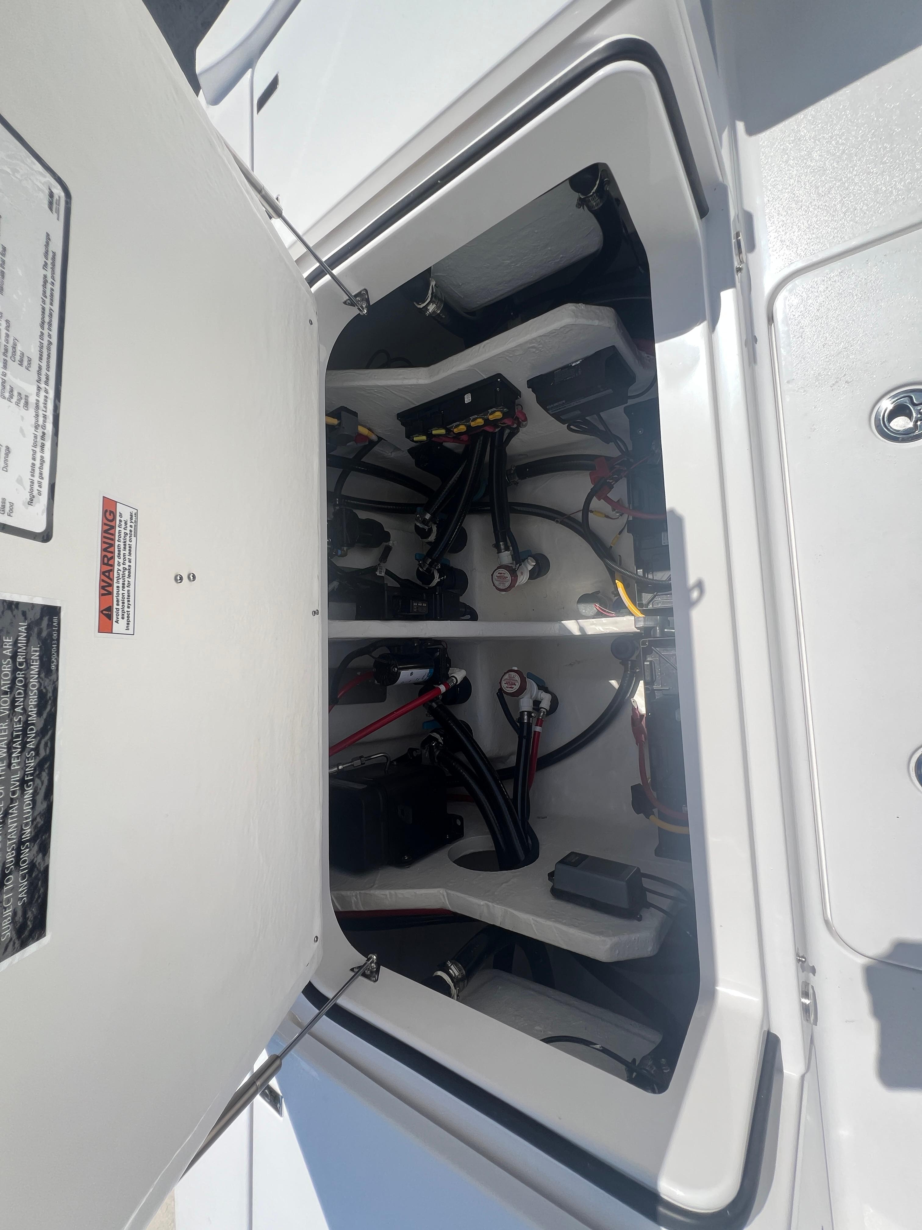 Open hatch of 2026 Blackfin 262 HB boat showing internal wiring and components.