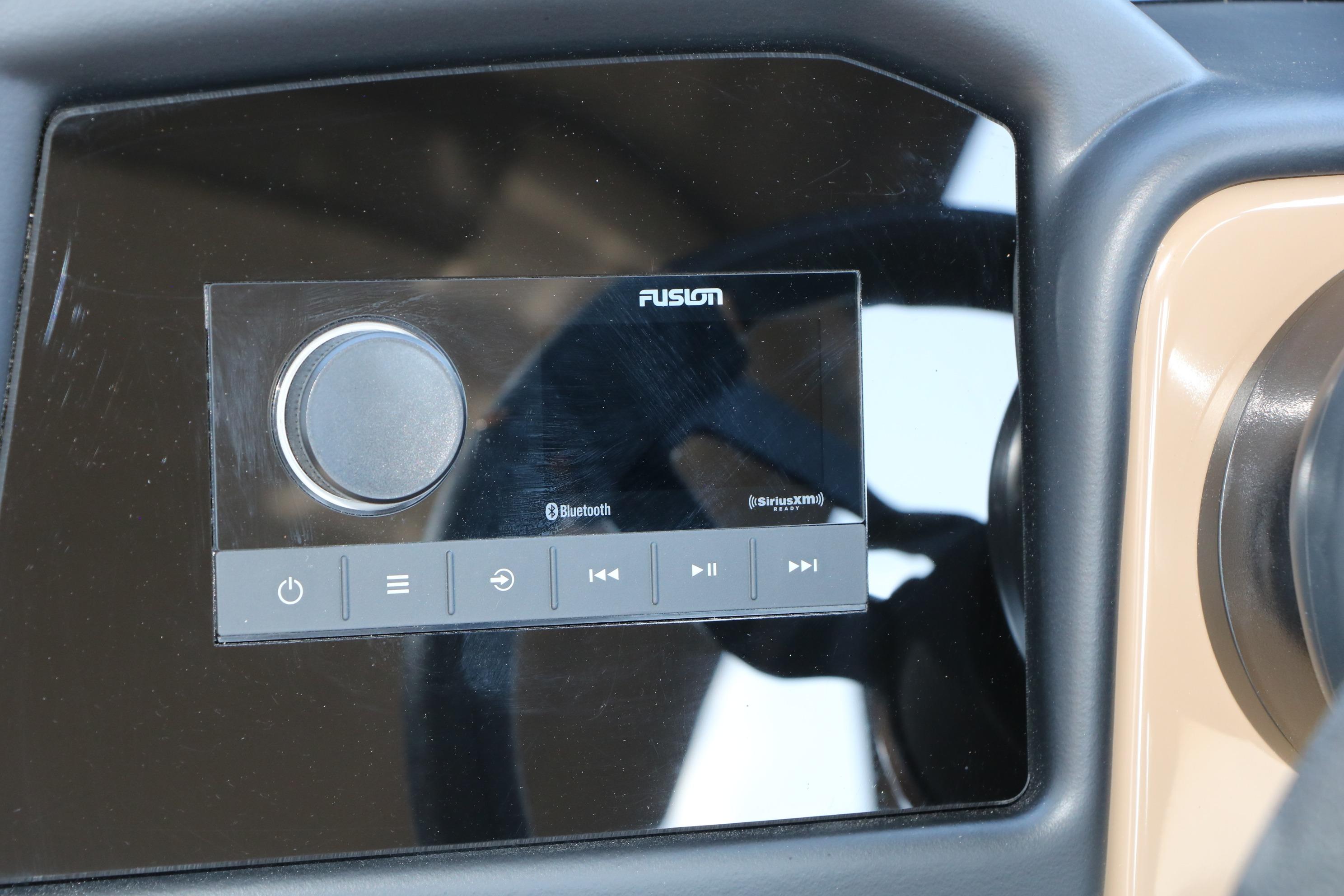 Fusion audio system on 2026 Evotti 725 CS Tri-Toon dashboard with Bluetooth and SiriusXM features.