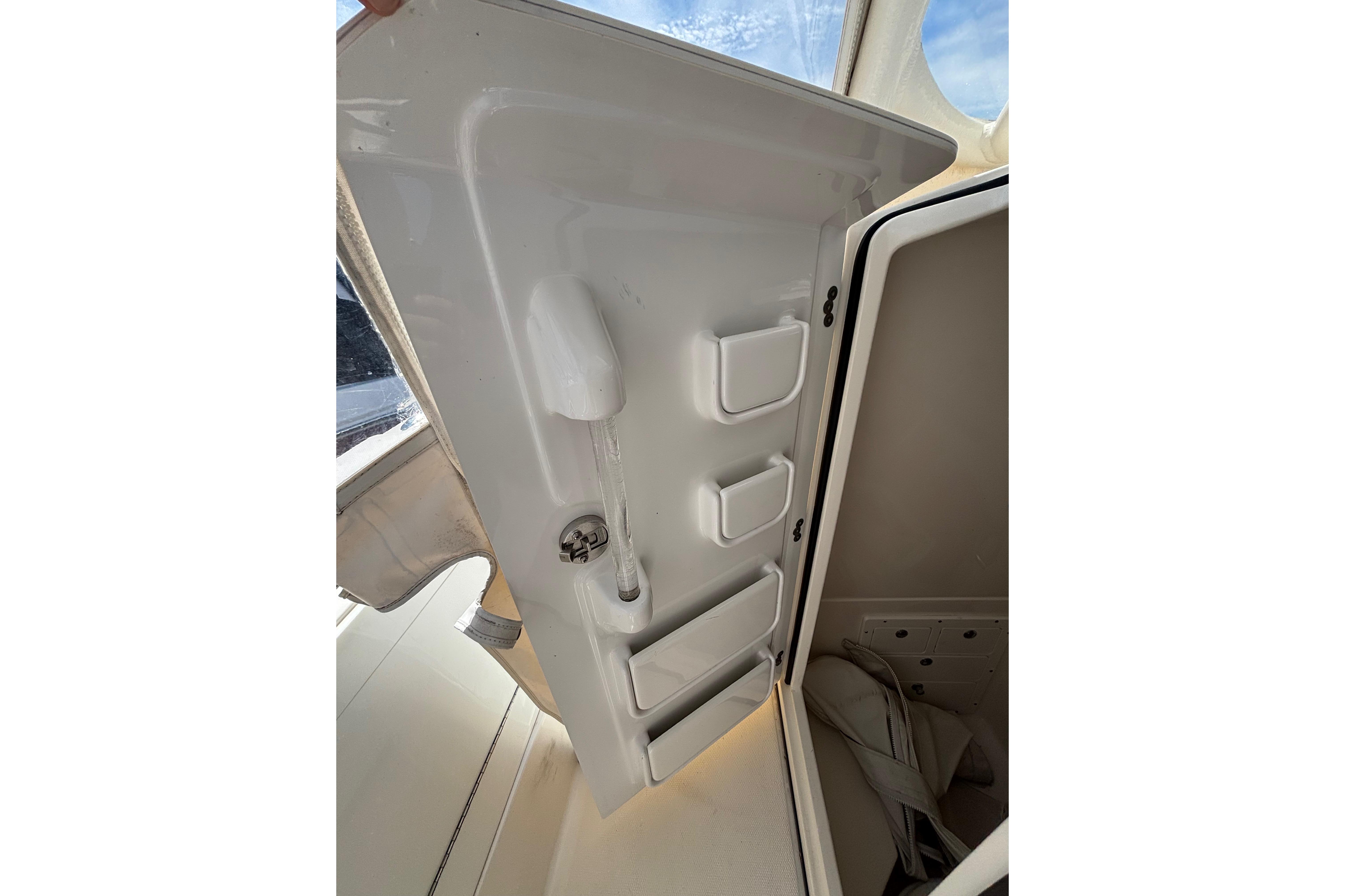 2006 Edgewater 318CC boat storage compartment with open door and interior view.