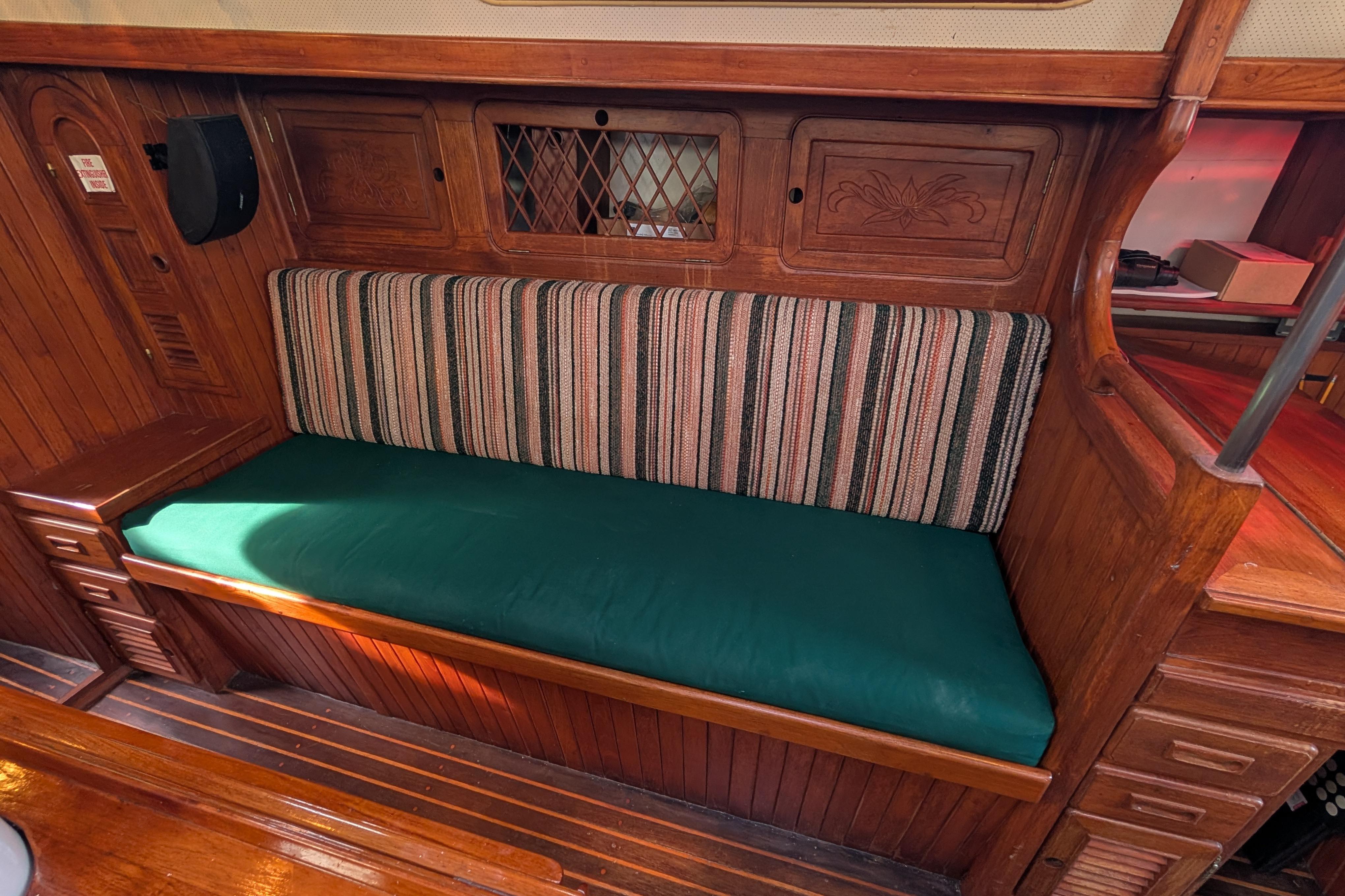 Vintage 1983 Robert Perry 41 sailboat interior with wooden cabinetry and striped upholstery.