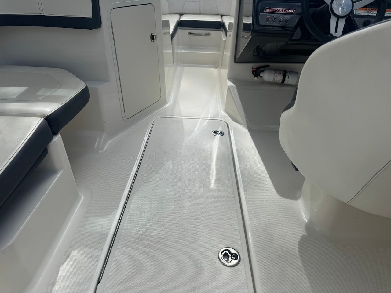 Interior of a 2016 Sea Ray SPX 190 Outboard with white seating and a steering console.