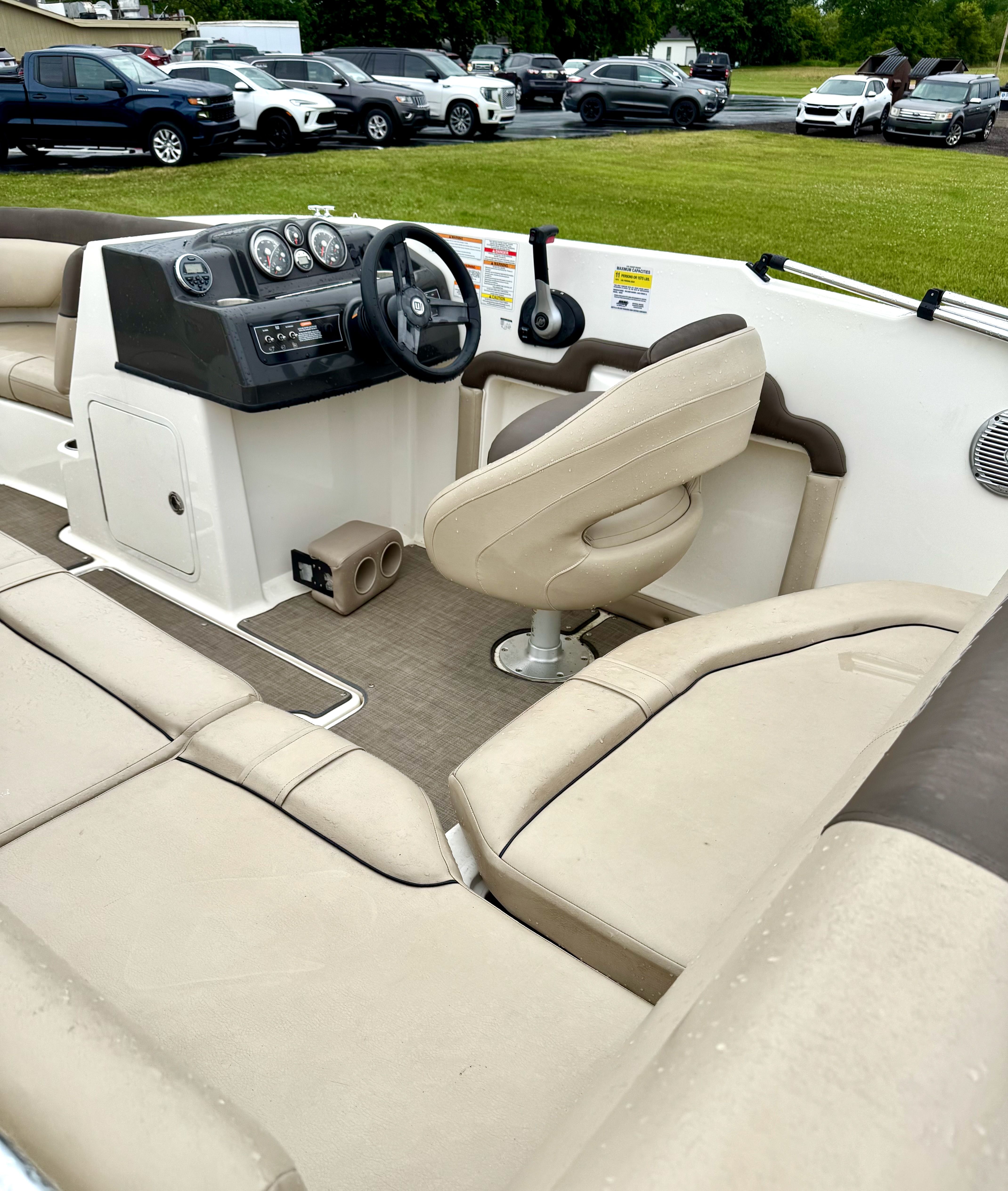 Interior of a 2017 Bayliner Element E18 with beige seating and a steering console.