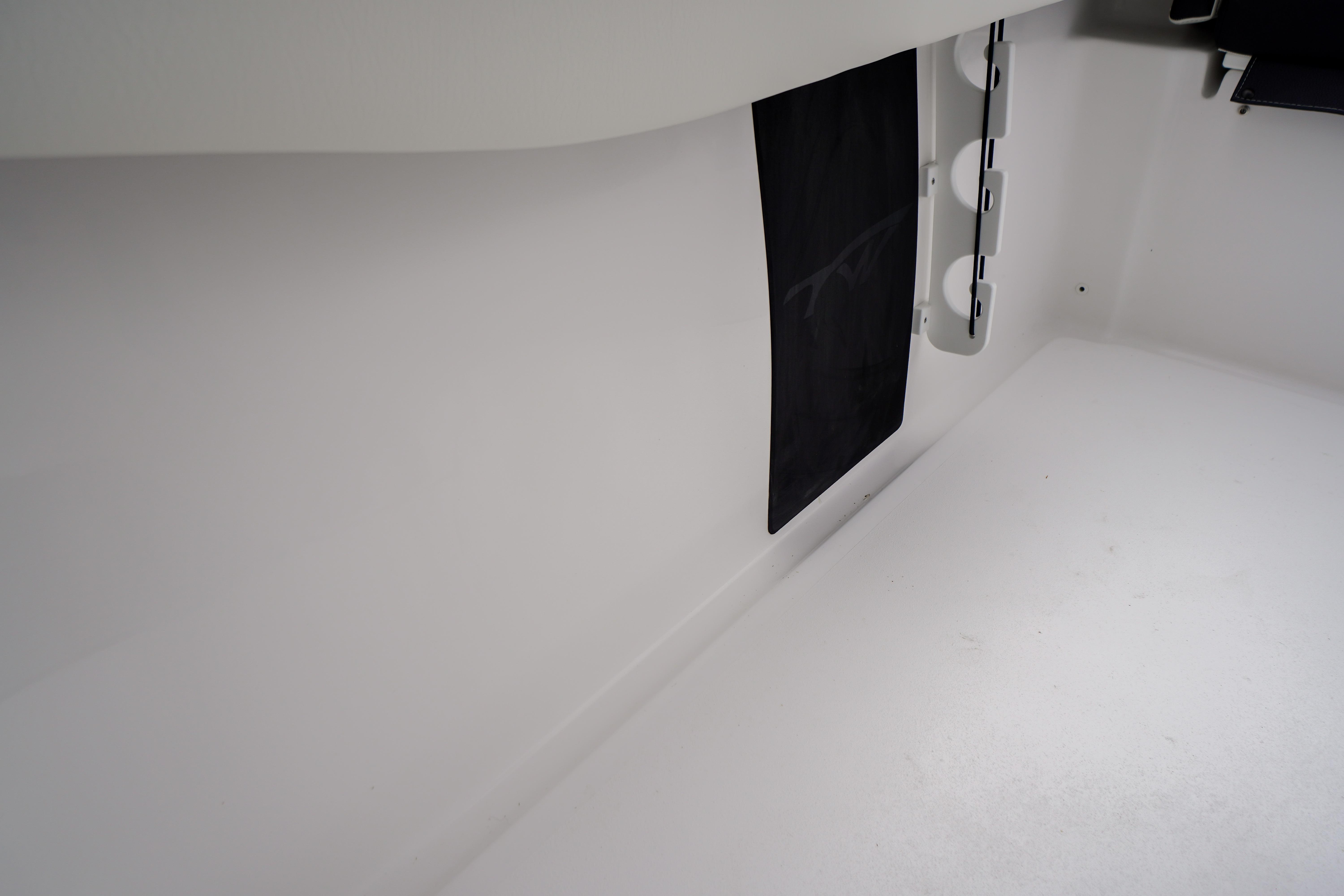 Interior view of 2026 Tidewater 232 SS boat, showcasing sleek white design and storage features.