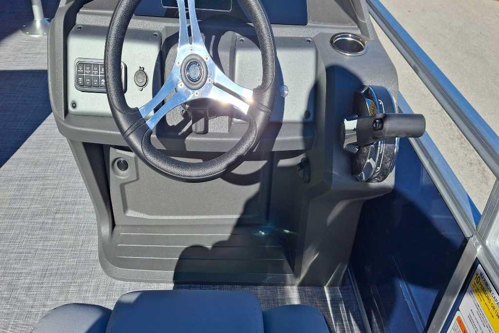 2026 Sun Tracker SportFish 20 DLX boat steering console with controls and cup holder.
