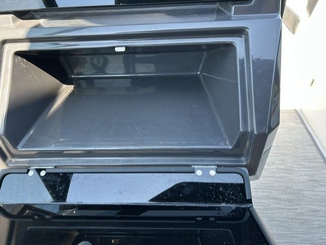An open storage compartment on a boat with a black frame.